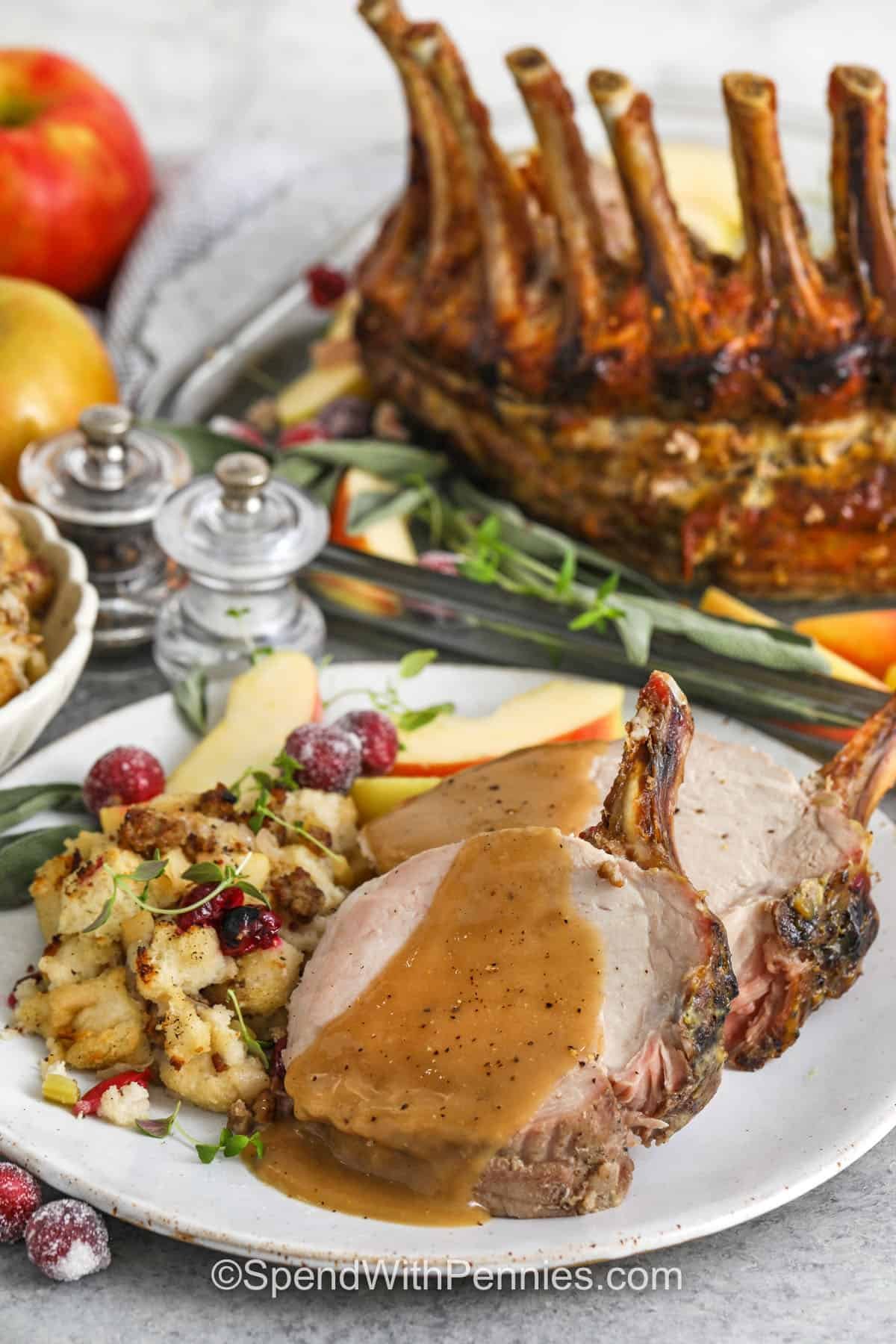 plated Pork Crown Roast with stuffind and a dish of the roast in the back