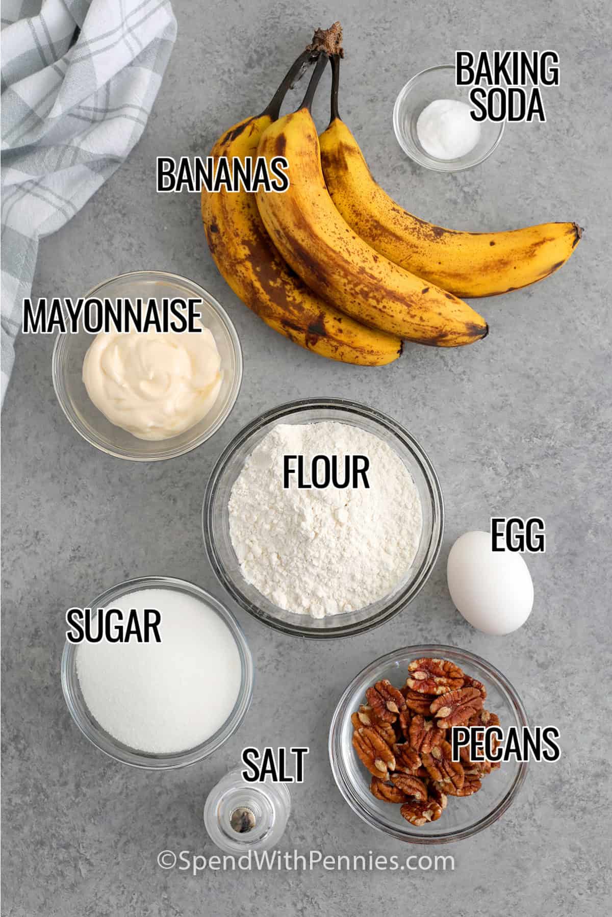 Bananas, baking soda, mayonnaise, sugar, flour, egg, salt, and pecans with labels to make Easy Banana Bread