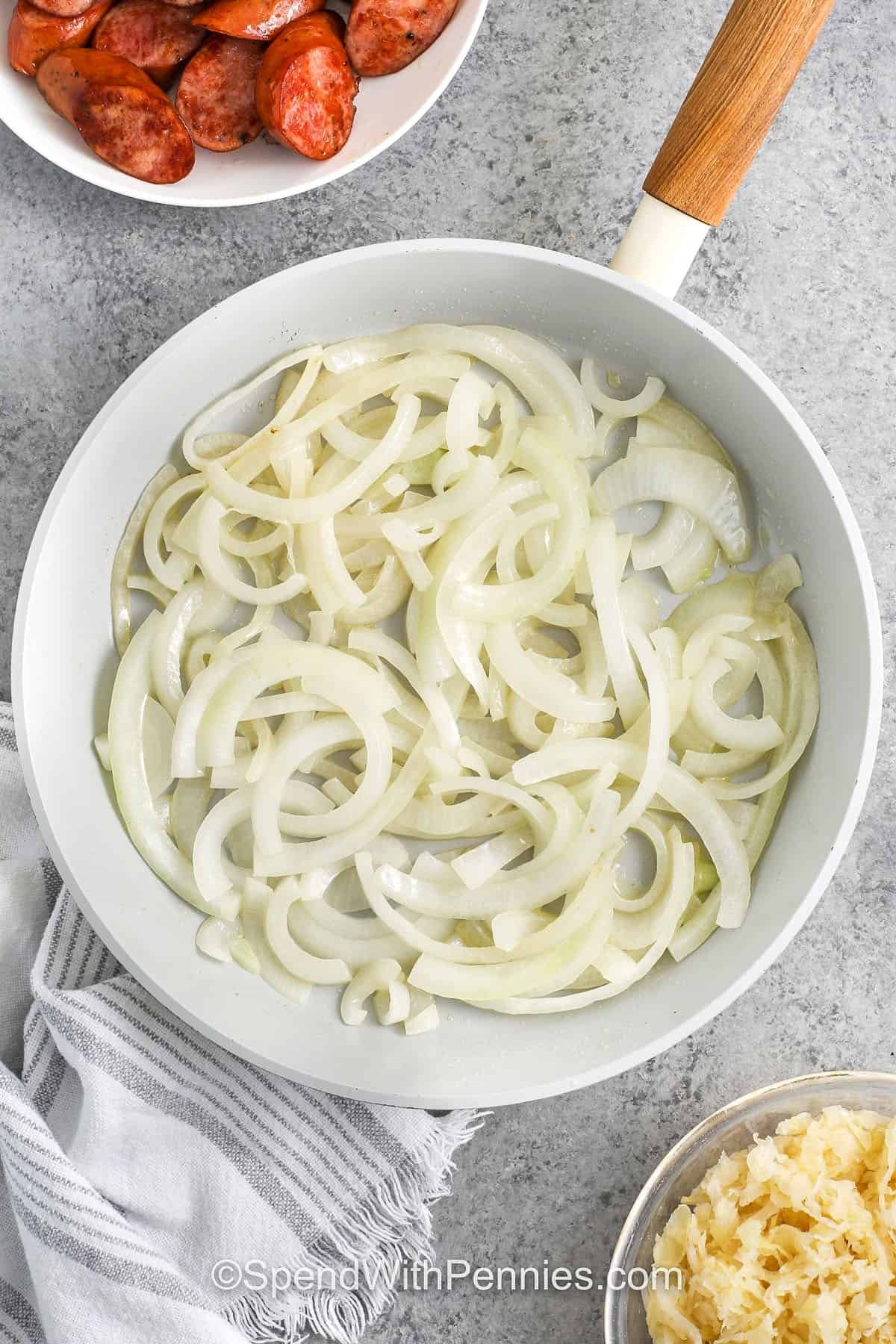 adding onions to pan to make Kielbasa and Sauerkraut