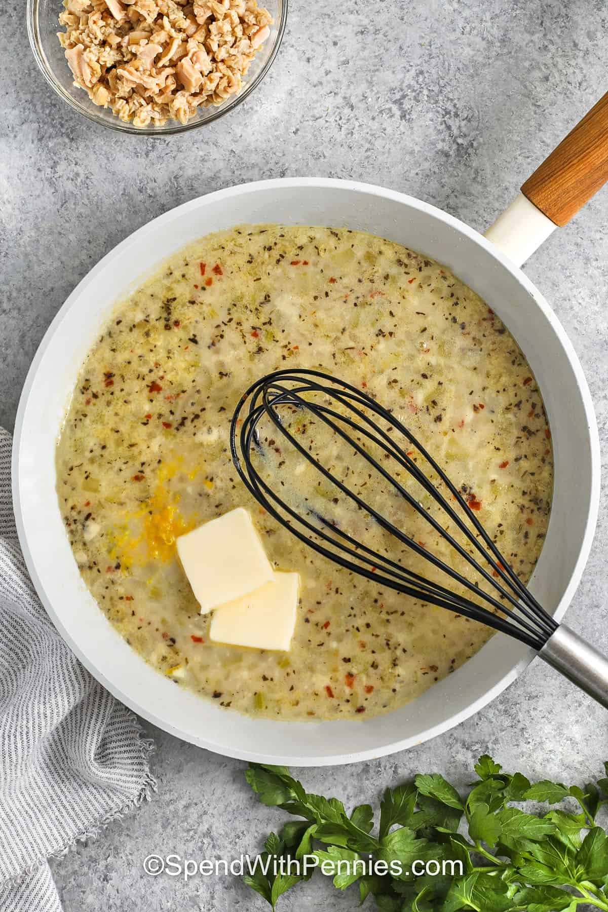 Linguine with clam sauce is a fresh, flavorful pasta recipe that combines tender clams, garlic, and onion in a bright white wine sauce. Tossed with linguine and finished with butter, lemon zest, and parsley, this dish is savory and comforting while still feeling light. Perfect for spaghetti lovers looking for the best way to make a seafood pasta dinner, it turns pantry staples into a restaurant-quality meal everyone will enjoy. #spendwithpennies adding butter and lemon to pan to make Linguine with Clam Sauce