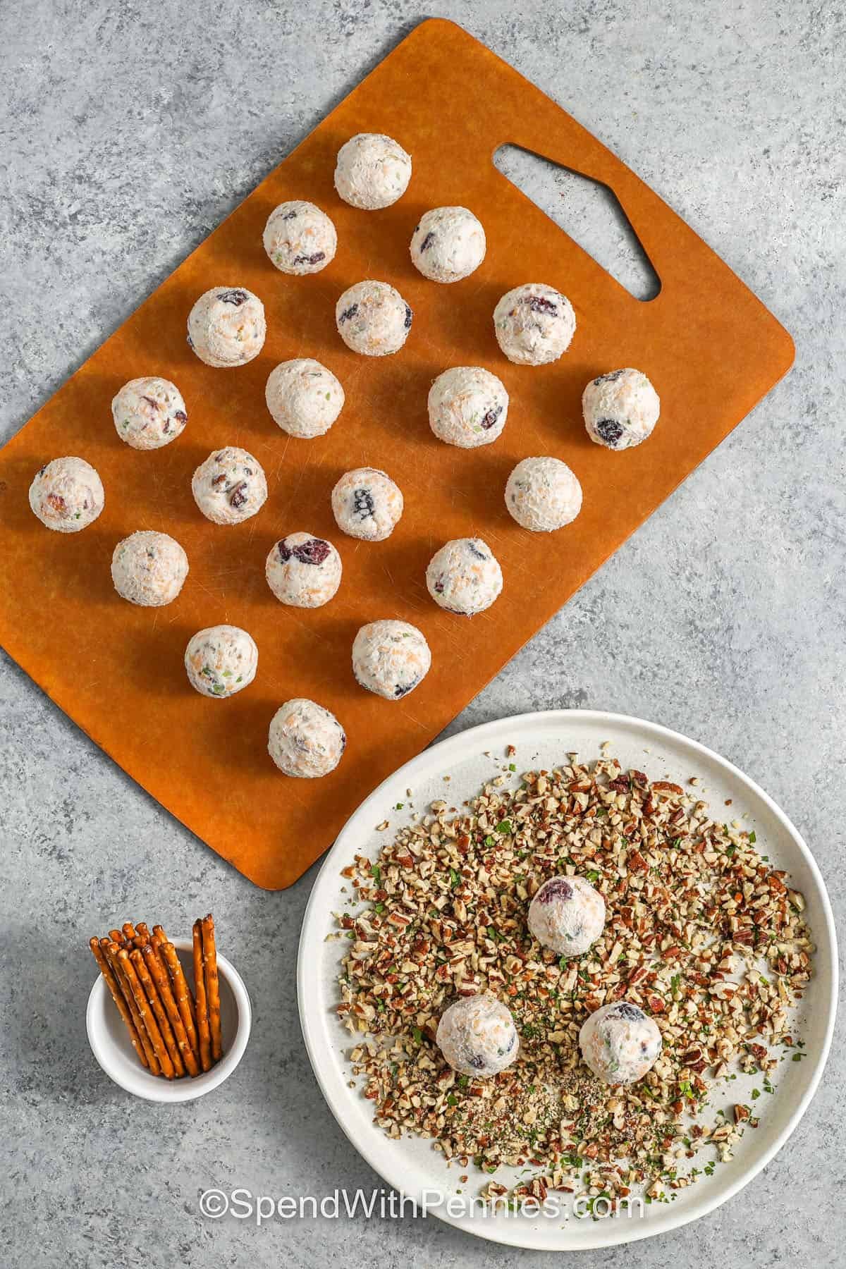 dipping Mini Cheese Balls in pecan coating