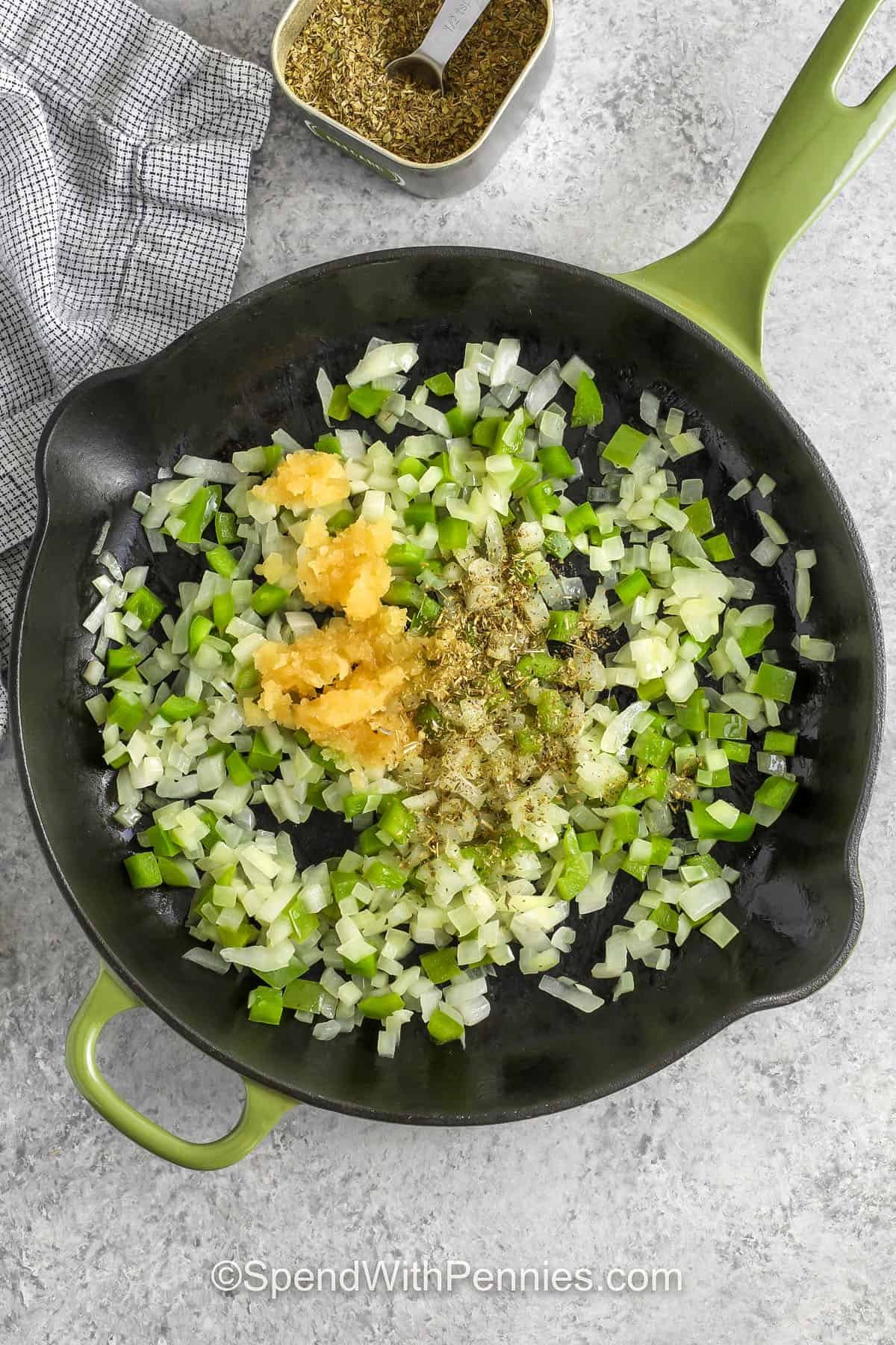 Pizza beans are an easy skillet meal with tender beans, pizza and tomato sauce, and pepperoni baked until the cheese is golden. The aroma is warm and inviting. Add Black olives or spinach for extra color or texture, and serve with bread or focaccia for a tasty finish. #spendwithpennies adding seasonings and garlic to onion and peppers to make Pizza Beans