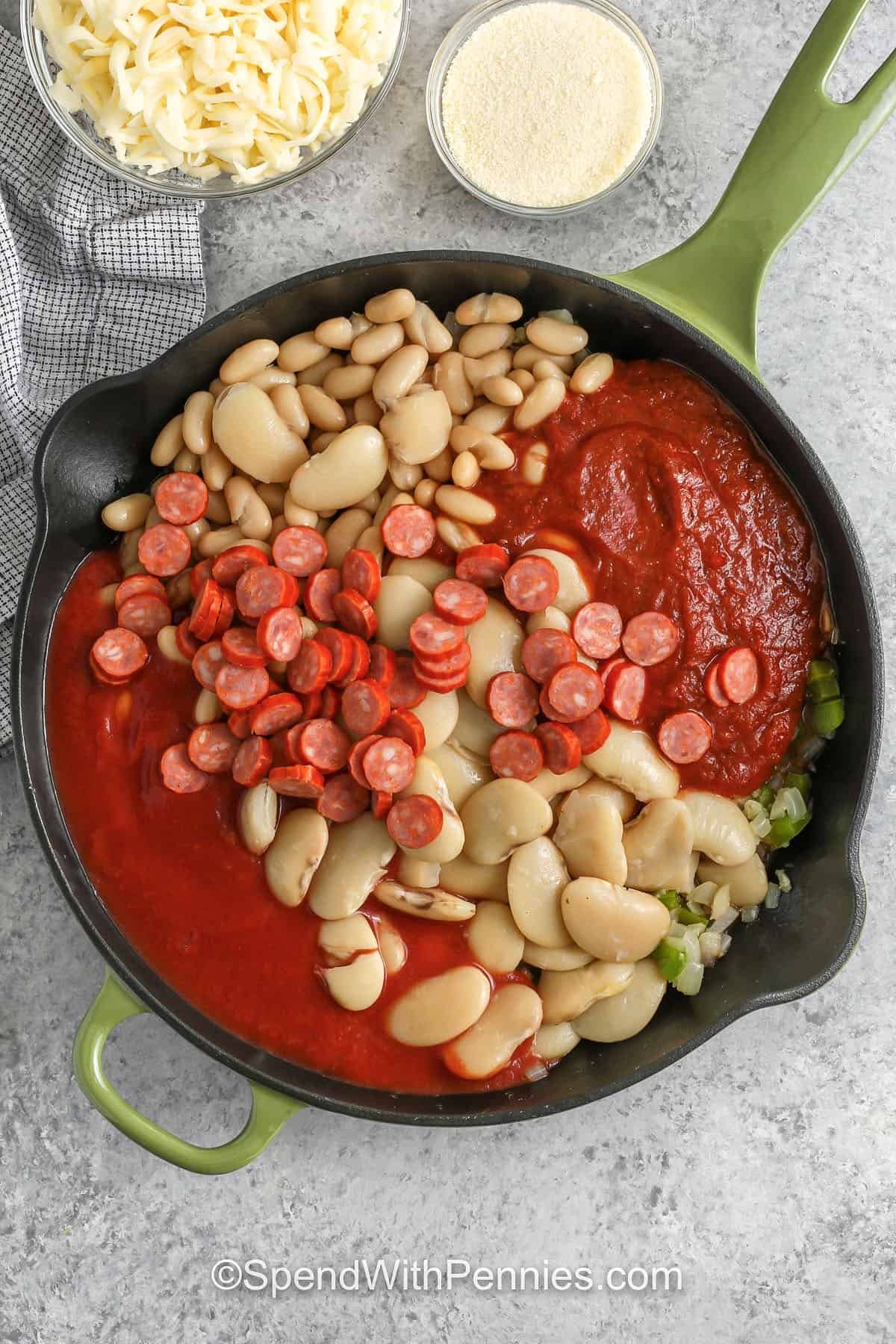 Pizza beans bring tender beans, pizza sauce, tomato sauce, and a sprinkle of pepperoni together for a dish that feels comfy and homey. The melted cheese forms a golden top that makes it taste like a baked skillet meal. Add black olives or veggies to change it up. Warm bread or focaccia on the side helps scoop up every last bit of sauce. #spendwithpennies adding beans , tomato sauce and pizza sauce to cooked veggies to make Pizza Beans
