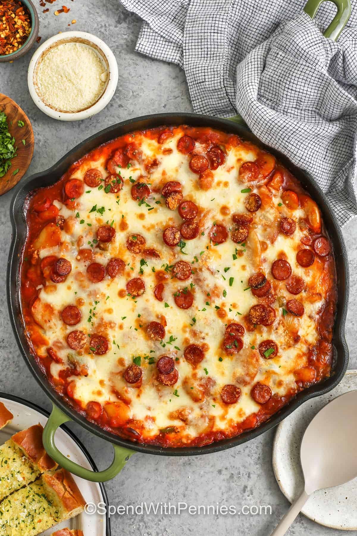 Pizza beans are a fun mix of tender white beans, rich pizza sauce, smooth tomato sauce, and bits of pepperoni that bake until the cheese melts into a tasty layer. The skillet turns bubbly, and the edges get slightly crisp. Add black olives or mushrooms if you like them. Serve with focaccia or garlic bread for a simple meal that feels special. #spendwithpennies Pizza Beans in the pan