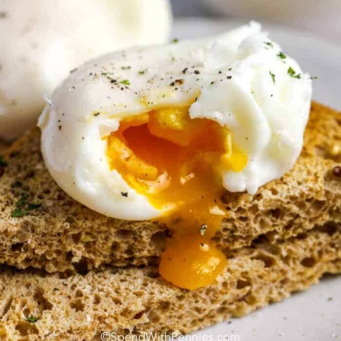 a poached egg broken open over toast