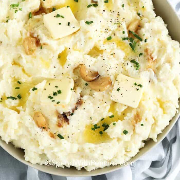 overview of Roasted Garlic Mashed Potatoes with butter and garlic garnish