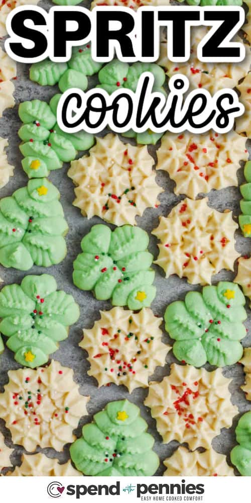 Cookie-press spritz cookies bake up crisp at the edges and soft in the center with beautiful Christmas designs. They use everyday ingredients and require minimal prep, making them ideal for quick holiday baking. Add sprinkles or food coloring before baking for a festive touch or keep them classic and simple. #spendwithpennies Spritz Cookies with sprinkles and a title