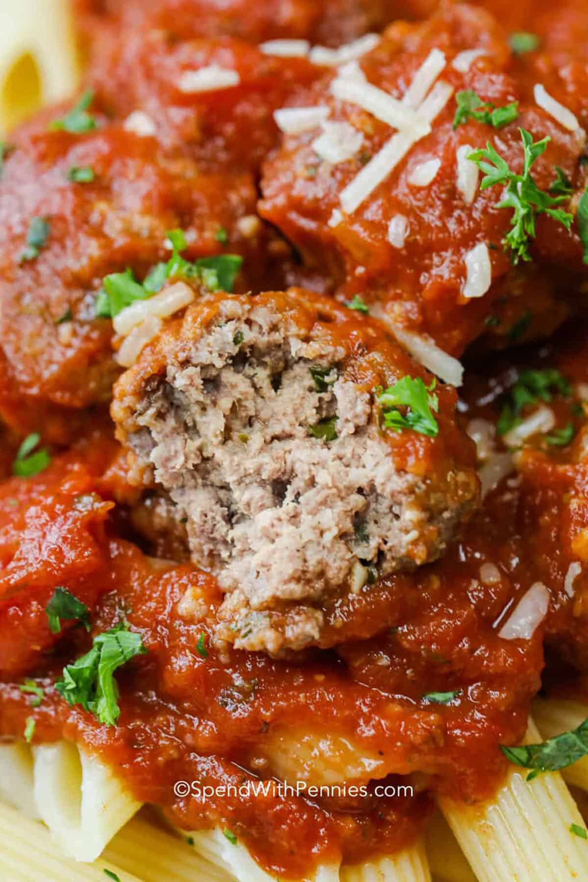 Crockpot meatballs are the easiest way to get tender, juicy meatballs without browning. A simple mix with Parmesan, parsley, and Italian seasoning cooks right in a rich marinara tomato sauce, so every bite stays flavorful. Serve these slow cooker meatballs over spaghetti, spoon extra sauce on top, and finish with more Parmesan for a cozy Italian-style dinner that is great for meal prep. #spendwithpennies Crockpot Meatballs with a bite taken out of one
