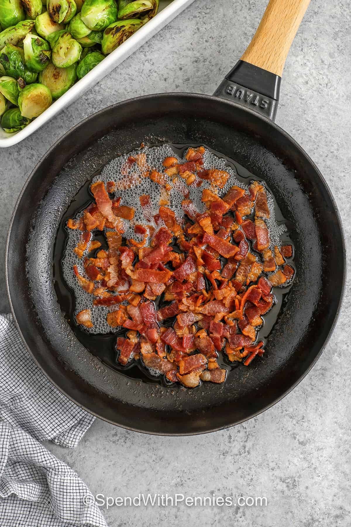 This creamy Brussel sprout casserole brings cozy holiday flavors to your table. Tender sprouts are smothered in cheesy sauce, topped with crispy bacon and a buttery layer. It makes a perfect side for Christmas dinners and can be prepared ahead of time. Everyone will love the comforting taste at winter gatherings. #spendwithpennies cooking bacon to make Brussels Sprout Casserole