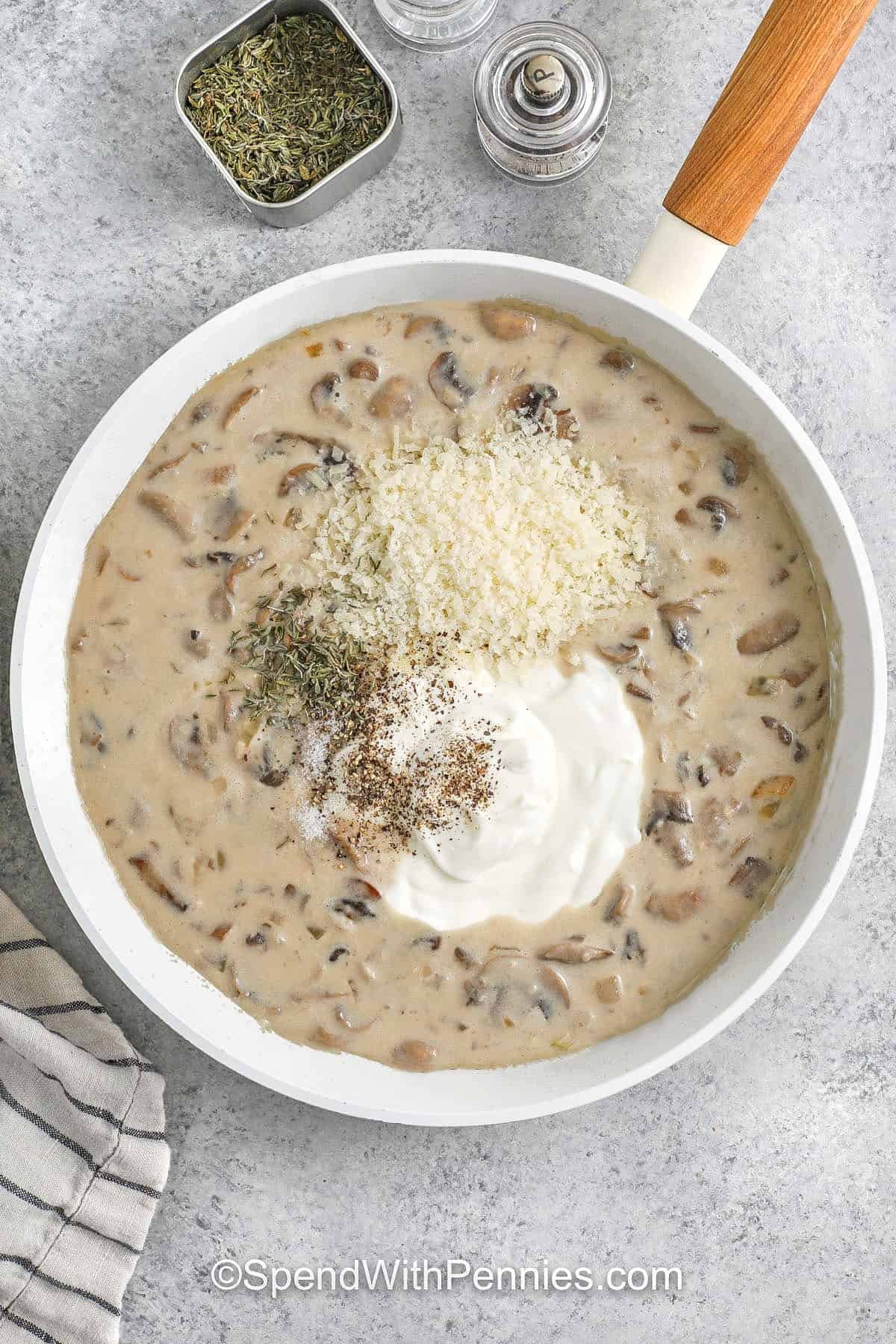 adding cheese , sour cream and seasonigns to mushroom mixture in pan to make Chicken Mushroom Casserole
