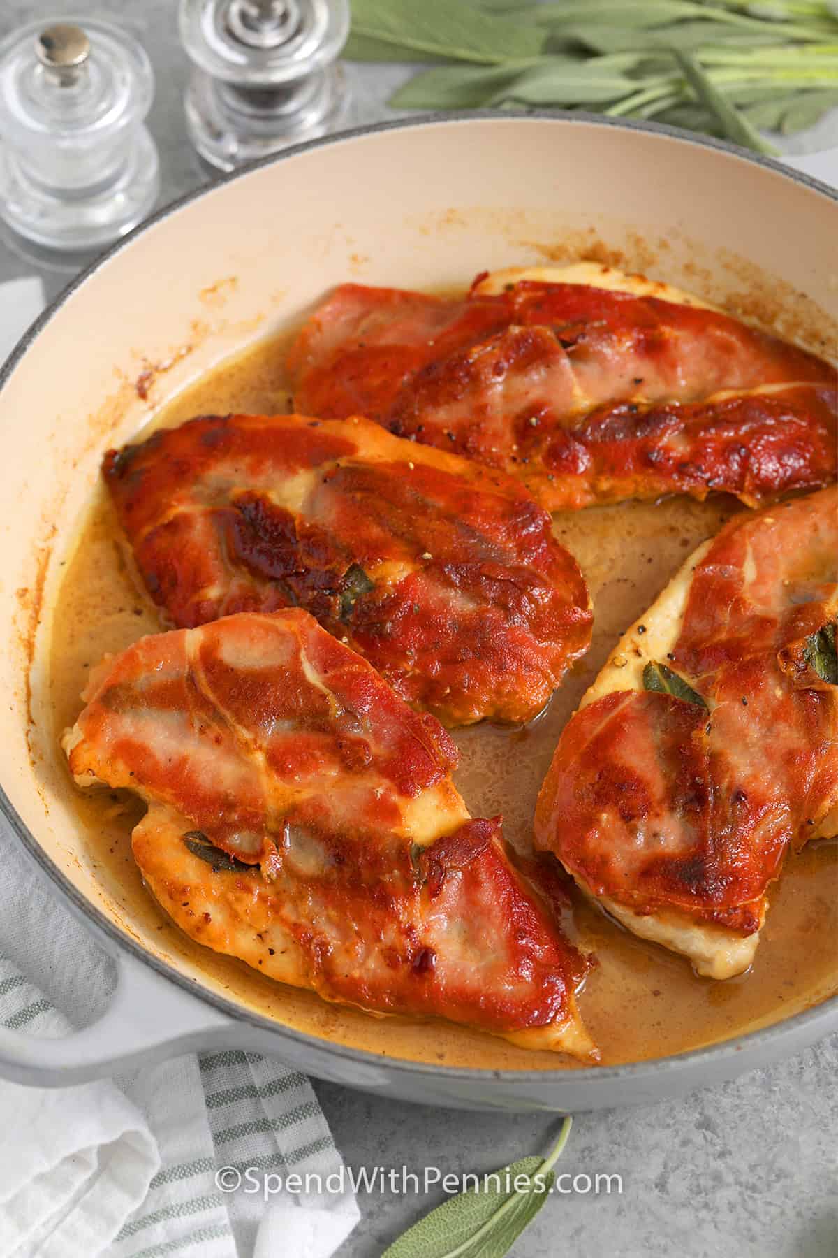 Close up of a skillet with chicken saltimbocca in a butter and white wine sauce