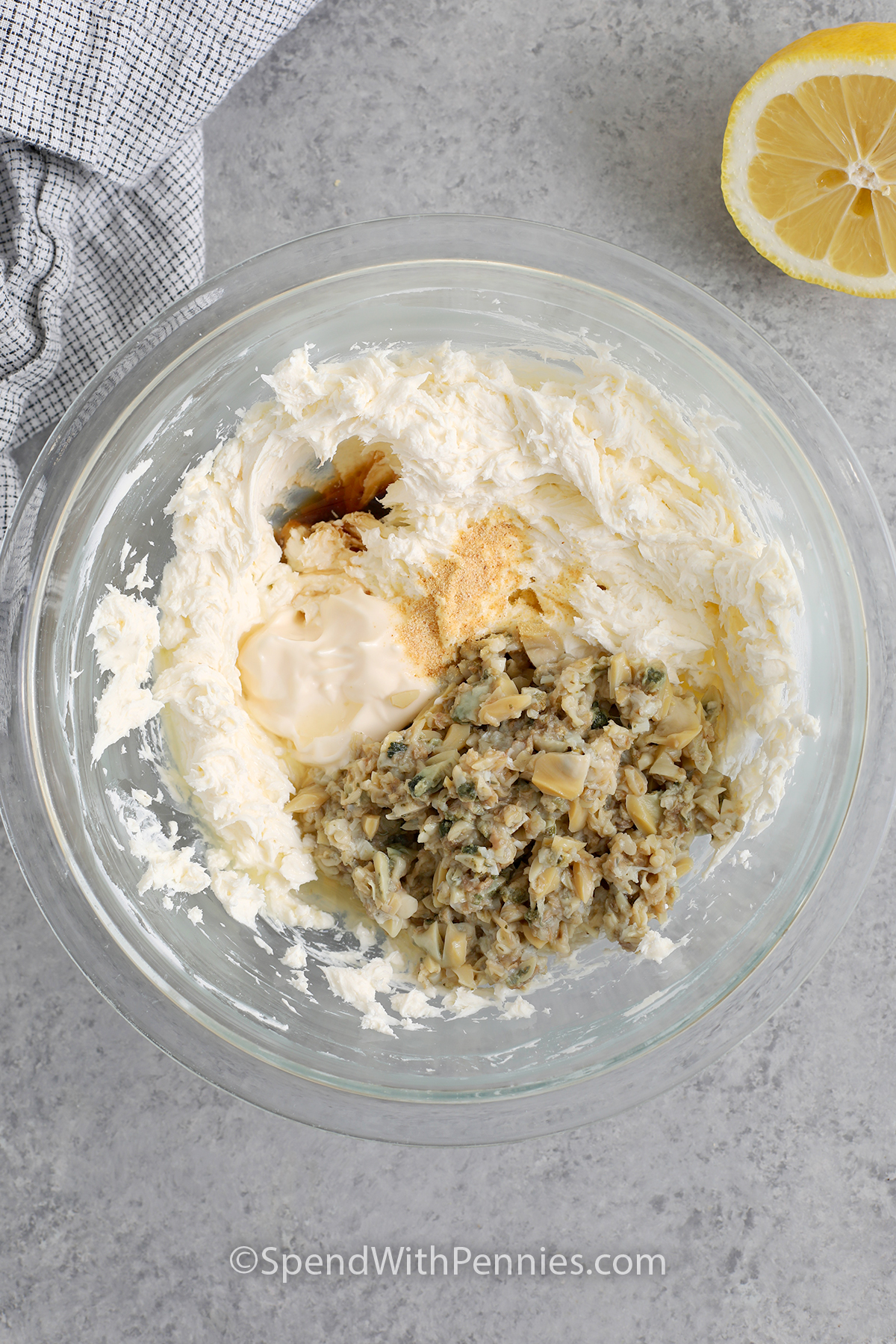 A mixing bowl with fluffy cream cheese, drained clams, mayonnaise, lemon juice, Worcestershire, garlic powder, and pepper to make Clam Dip