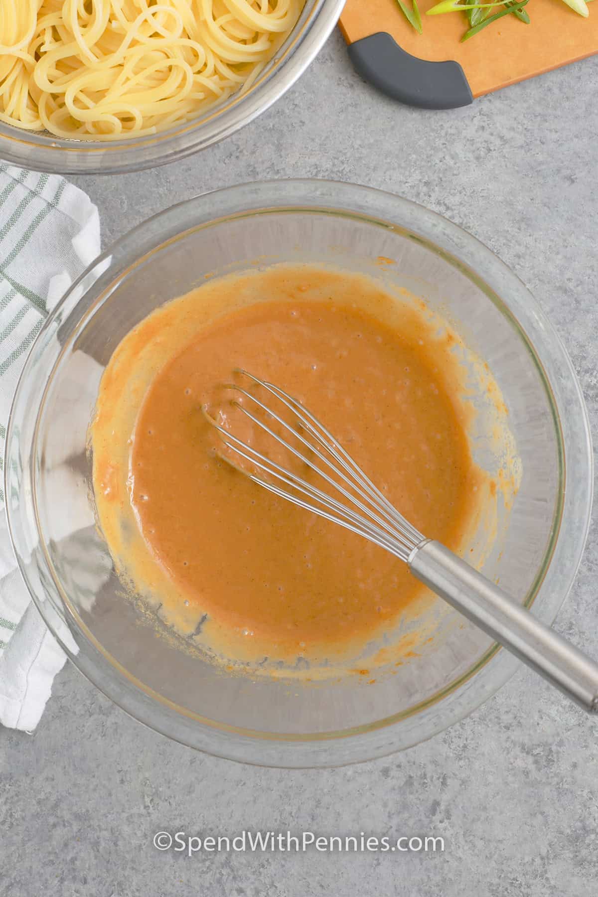 Peanut sauce in a bowl with a whisk to make cold sesame noodles