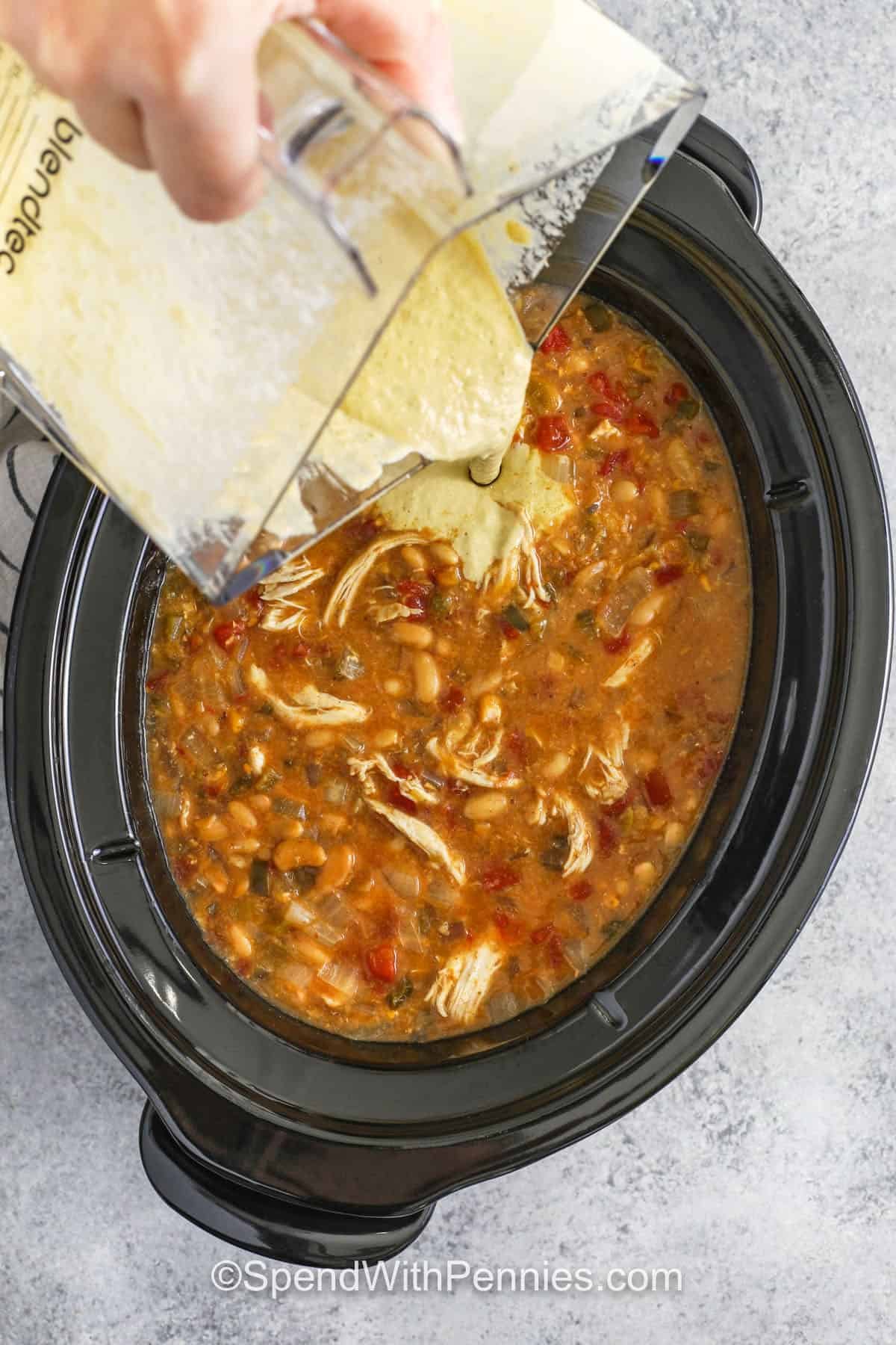 adding blended ingredients to crock pot to make Crockpot White Chicken Chili