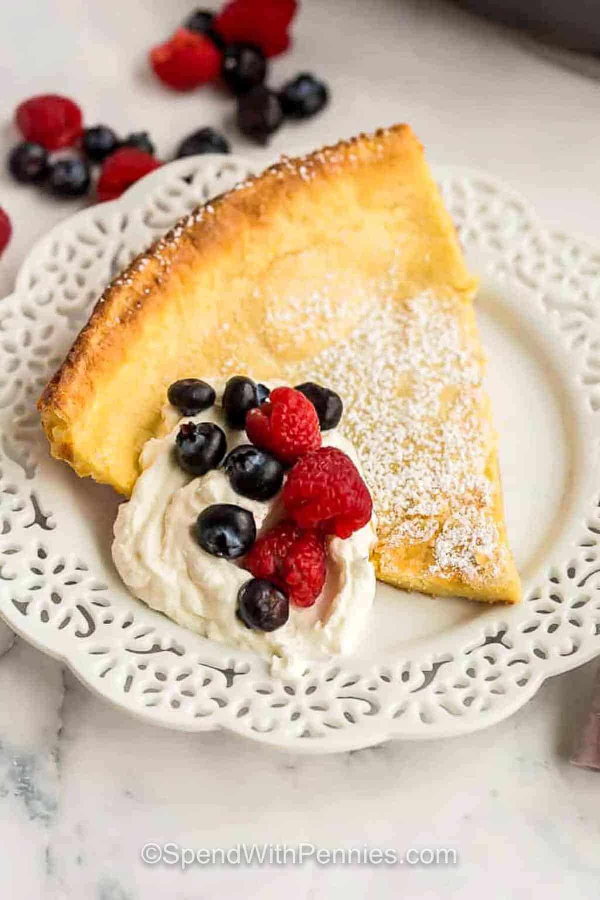 slice of Dutch Baby Pancakes with whipped cream and berries