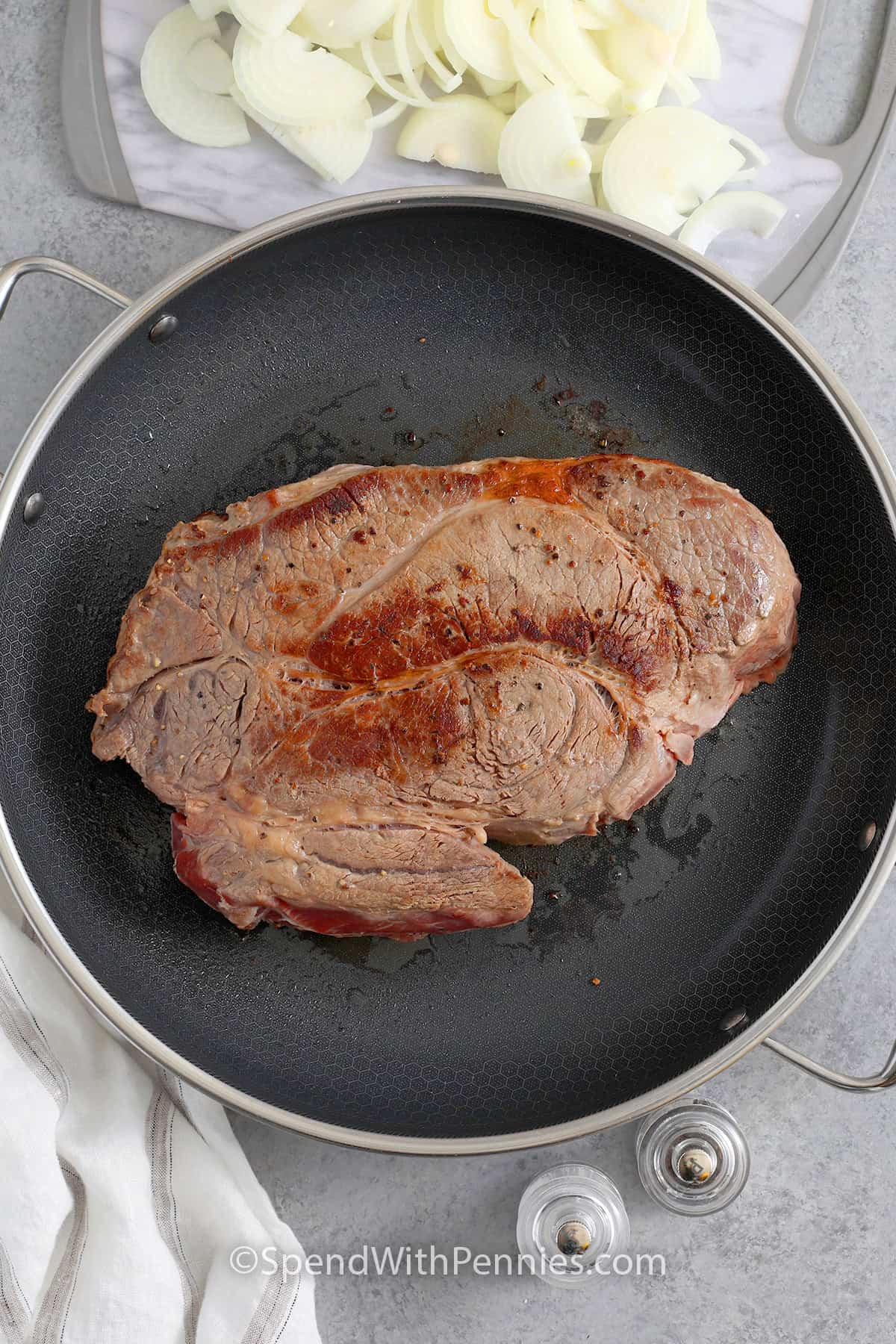 Chuck roast being seared in a skillet to make French Onion Pot Roast.