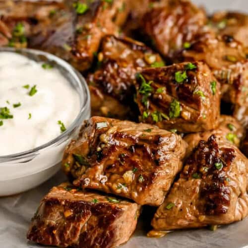 Garlic Butter steak bites on a serving plate with dip