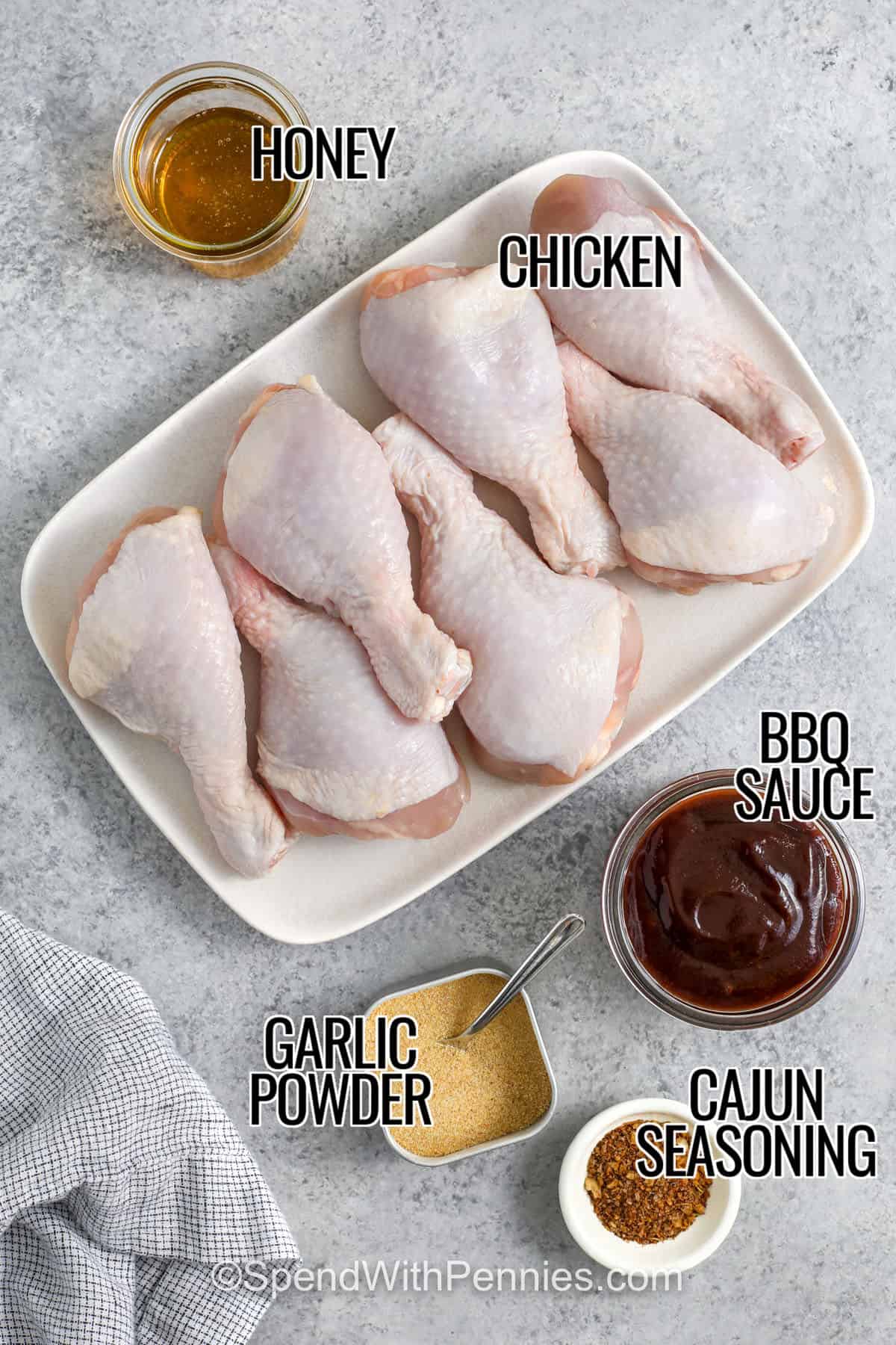 honey , bbq sauce , garlic powder , cajun seasoning and chicken with labels to make Slow Cooker Chicken Drumsticks