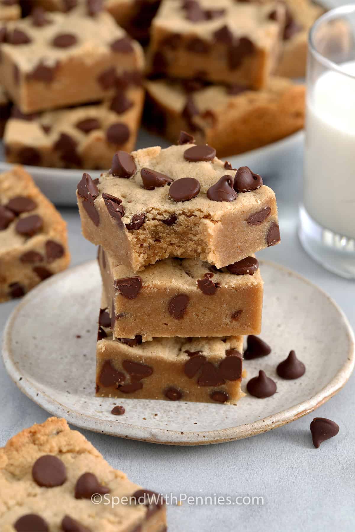 Stack of three Peanut Butter Cookie Bars on a plate with a bite out of the top one.