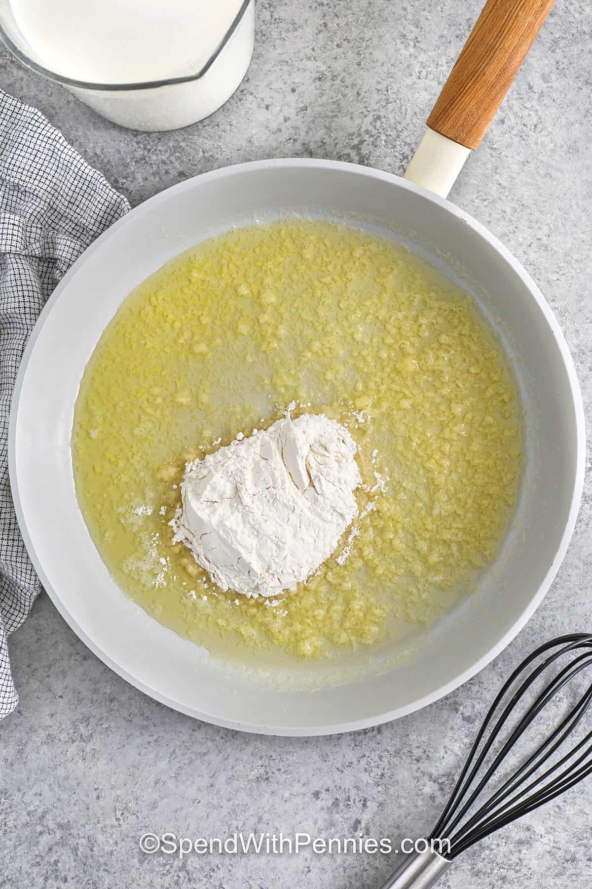adding flour to garlic and butter to make roux for Seafood Lasagna