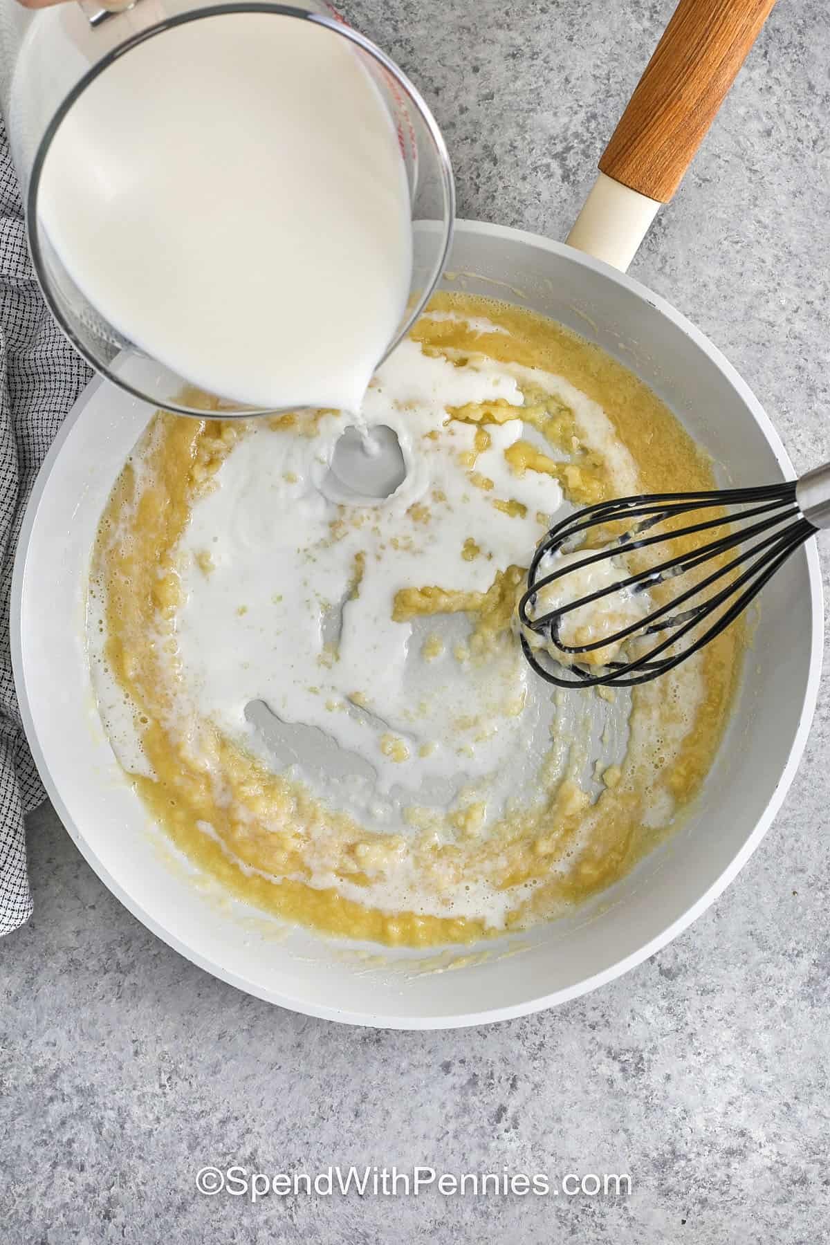 whisking in milk to roux to make Seafood Lasagna