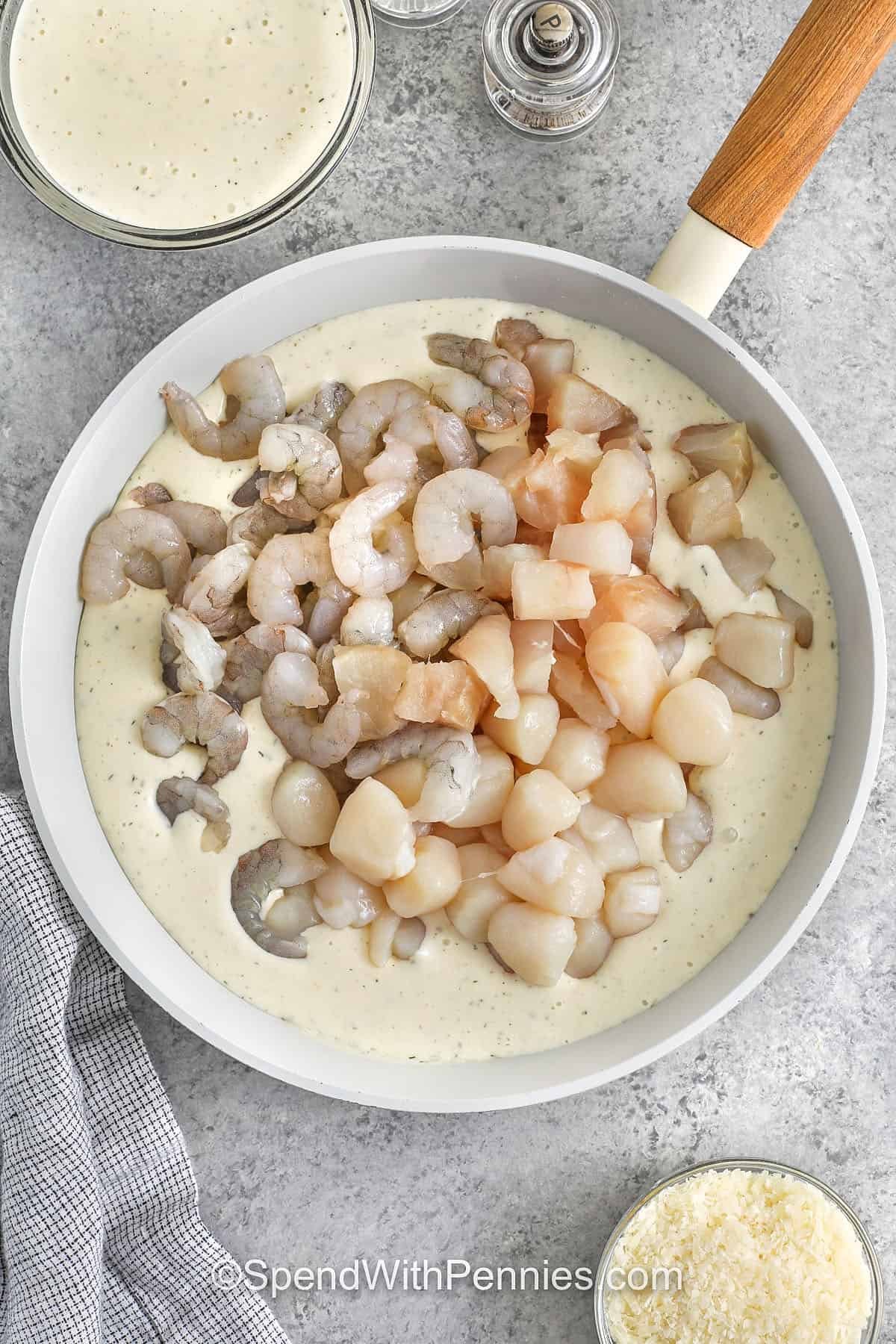 adding seafood to sauce to make Seafood Lasagna