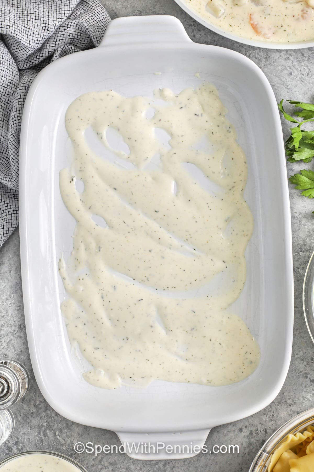 adding sauce to casserole dish to make Seafood Lasagna