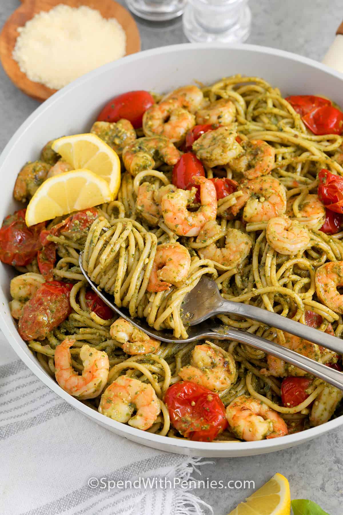 A skillet of Shrimp Pesto Pasta with some of the pasta wrapped around a fork