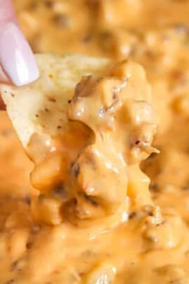 dipping a chip in Sausage Cheese Dip