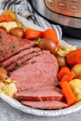 Instant Pot Corned Beef on a plate with potatoes and vegetables