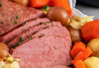 Instant Pot Corned Beef on a plate with potatoes and vegetables