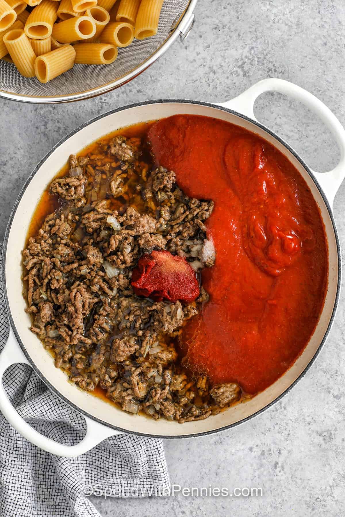 adding tomato sauce and tomato paste with broth to beef and onion mixture