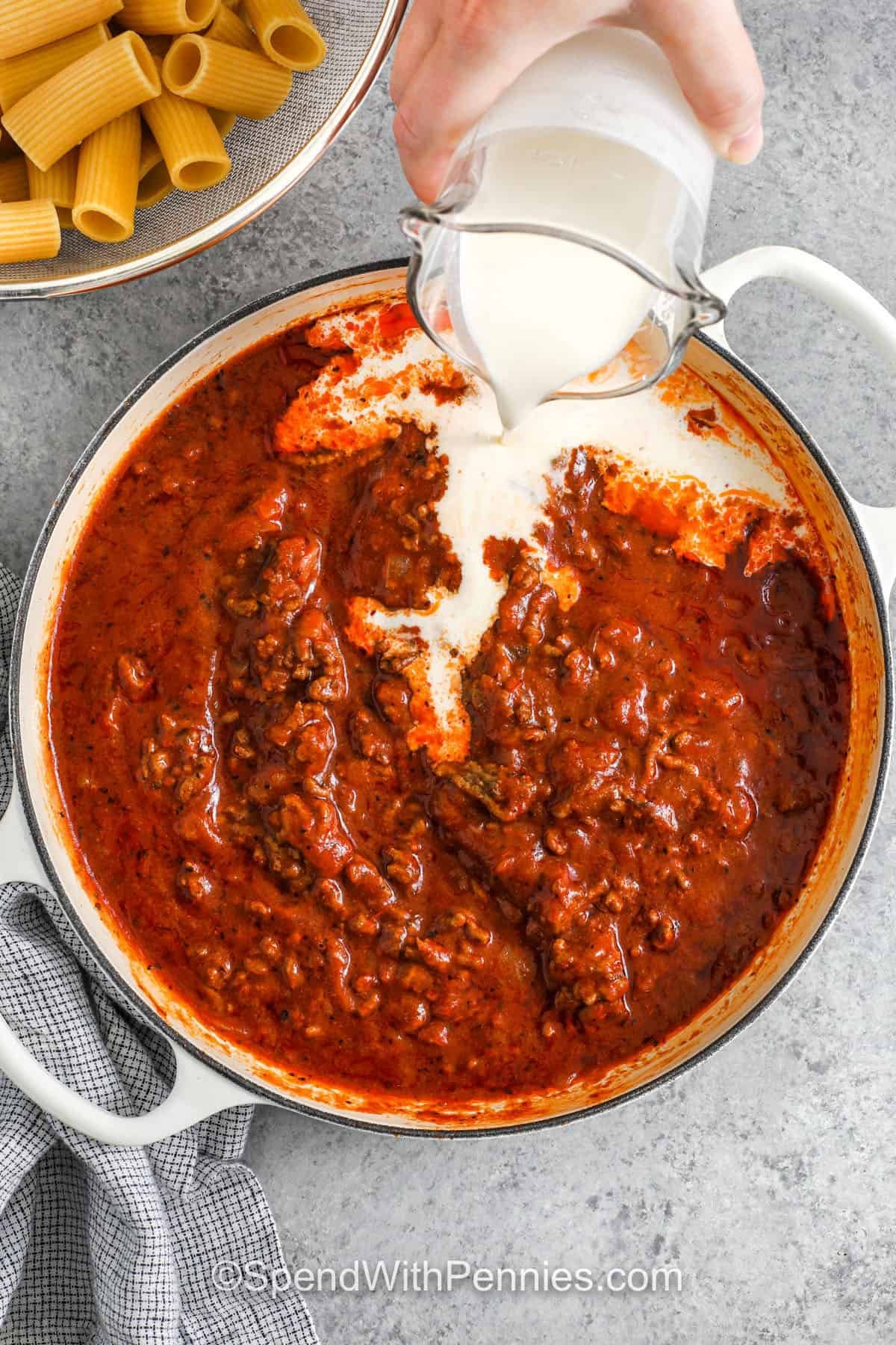 adding cream to Creamy Ground Beef Pasta sauce