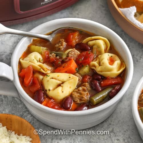 bowl of Crockpot Tortellini Soup with parmesan and bread