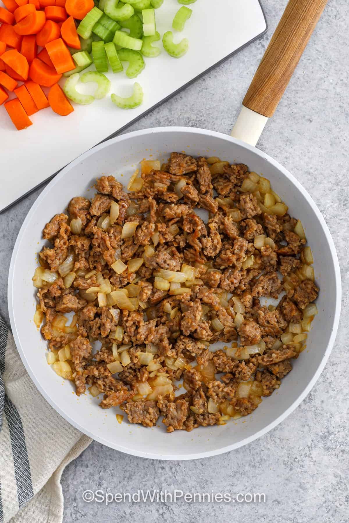 cooking italian sausage and onions to make Crockpot Tortellini Soup