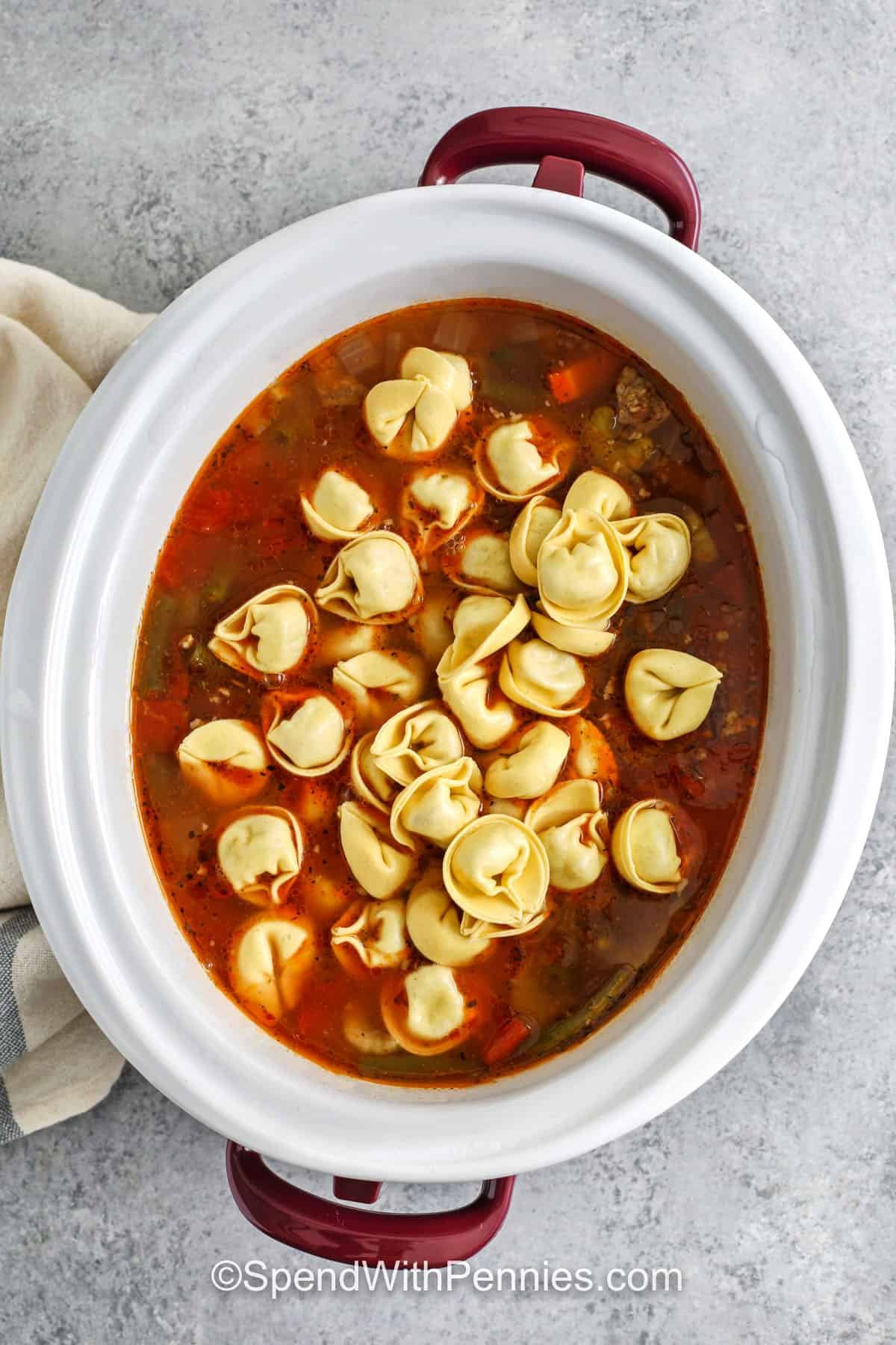 adding tortellini to crockpot to make Crockpot Tortellini Soup