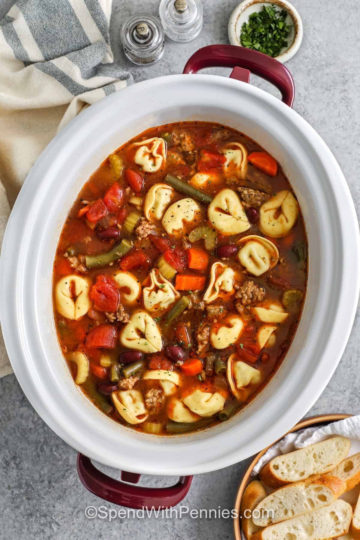 savory Crockpot Tortellini Soup with a bowl of bread