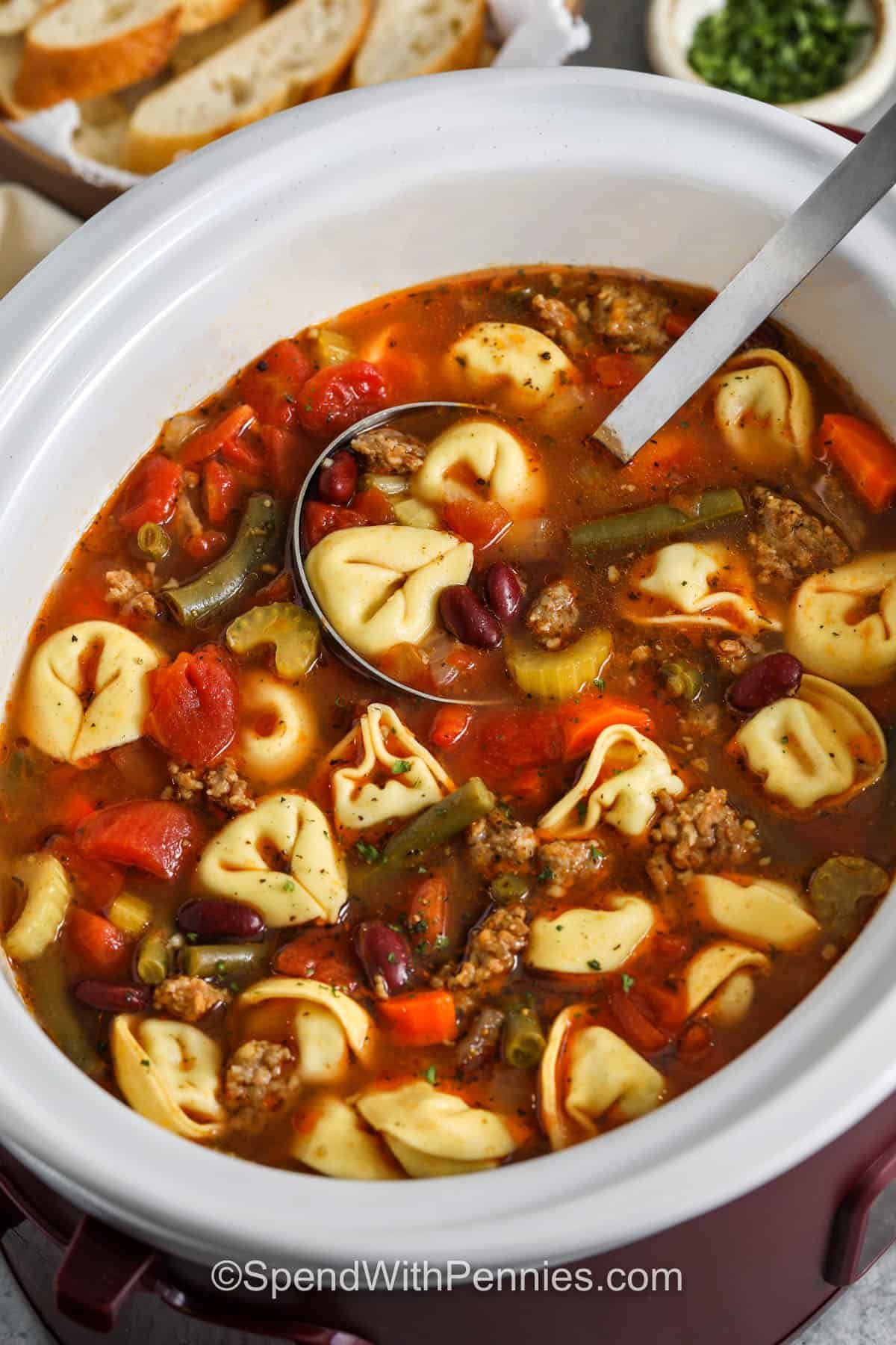 Crockpot Tortellini Soup in crockpot with a ladle