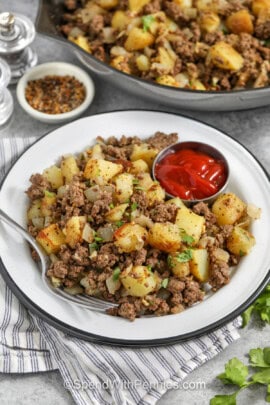 plated Hamburger Hash with pan full in the back