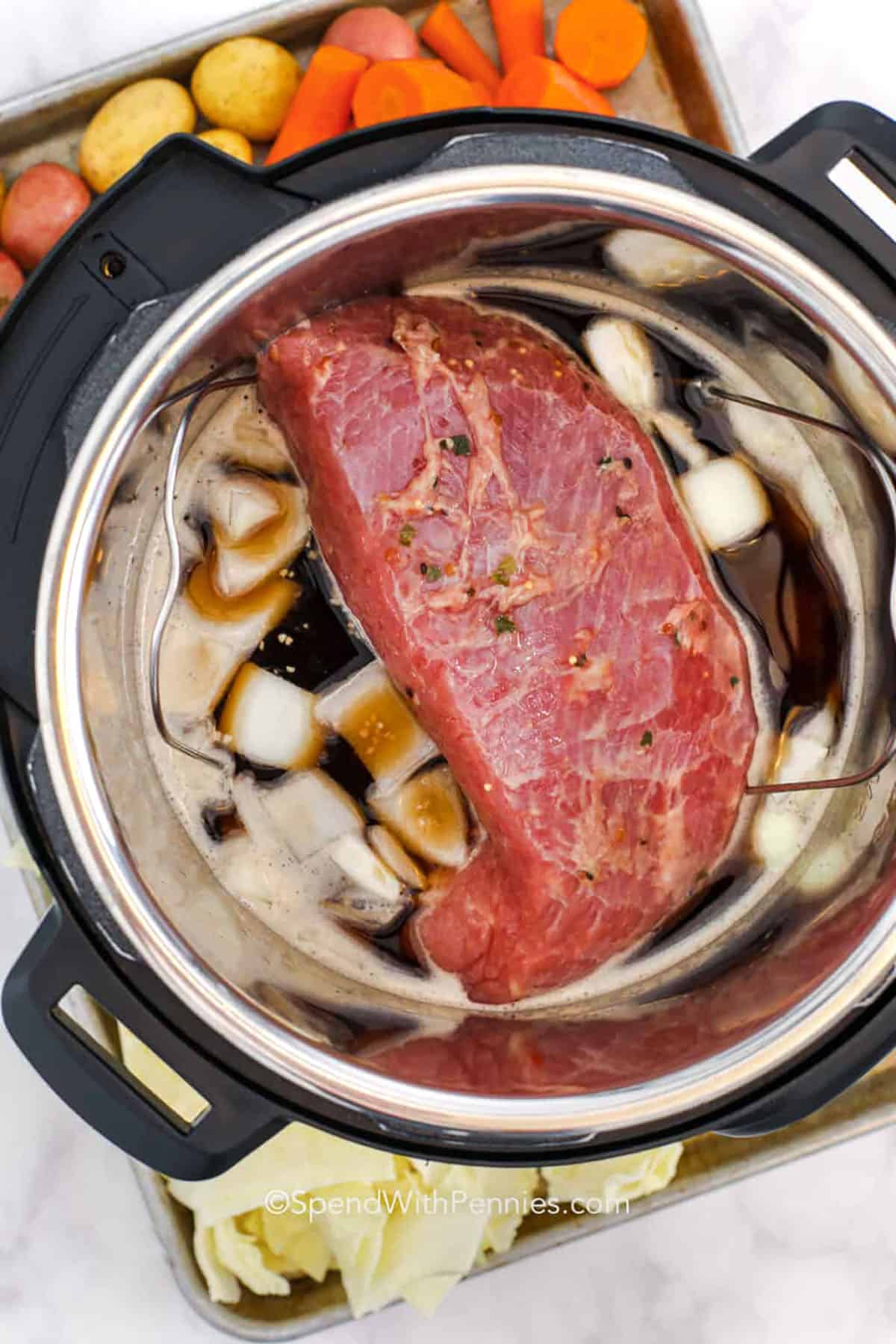 Make Instant Pot corned beef for a cozy winter dinner that feels special but stays easy. The brisket turns juicy and sliceable, while the seasoned cooking liquid becomes a warm finishing sauce for cabbage, carrots, and potatoes. This pressure cooker corned beef method keeps dishes to a minimum and makes leftovers perfect for Reuben sandwiches or corned beef hash. #spendwithpennies adding beef to pot with broth and onions to make Instant Pot Corned Beef
