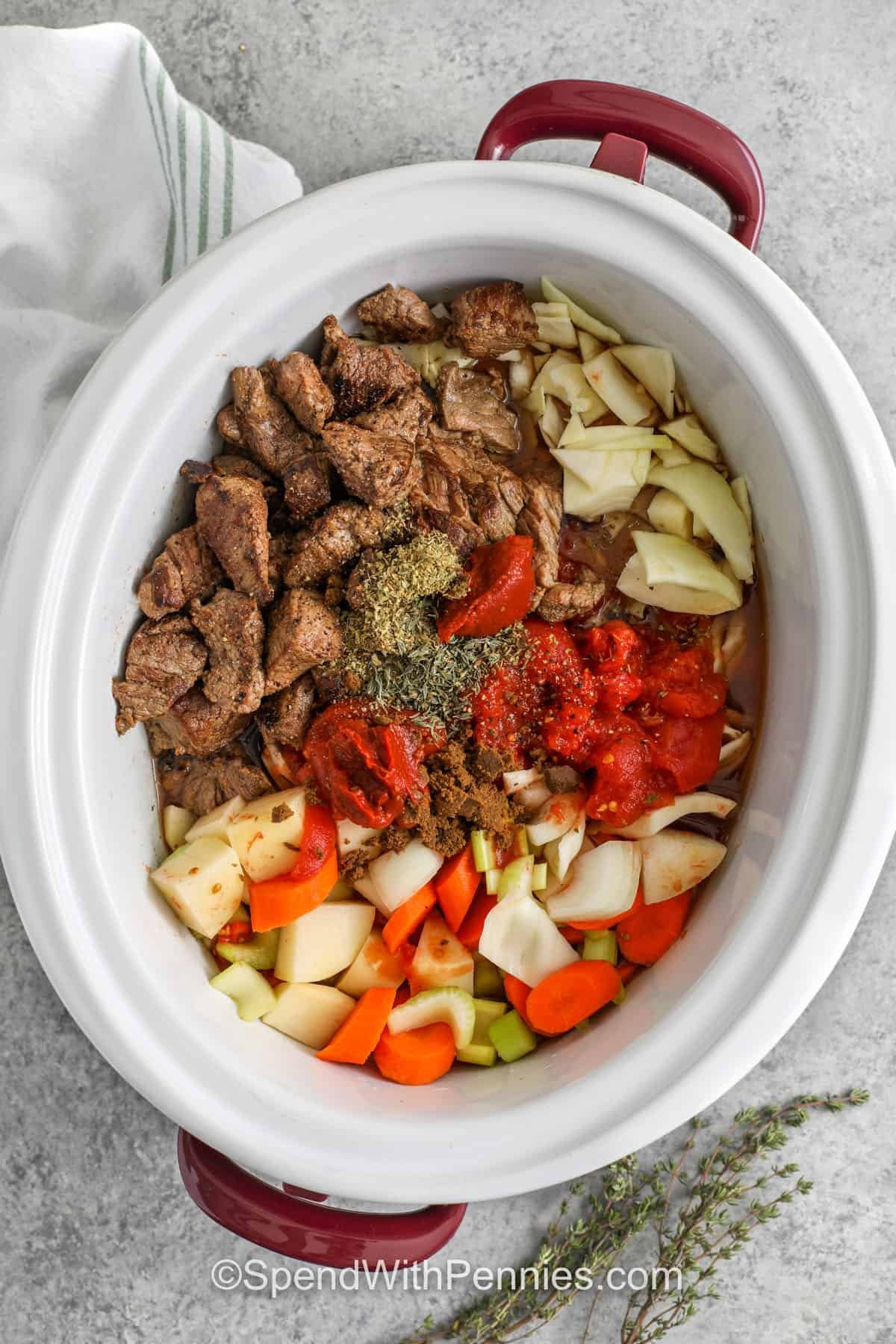 adding ingredients together in slow cooker to make Slow Cooker Beef and Cabbage Stew