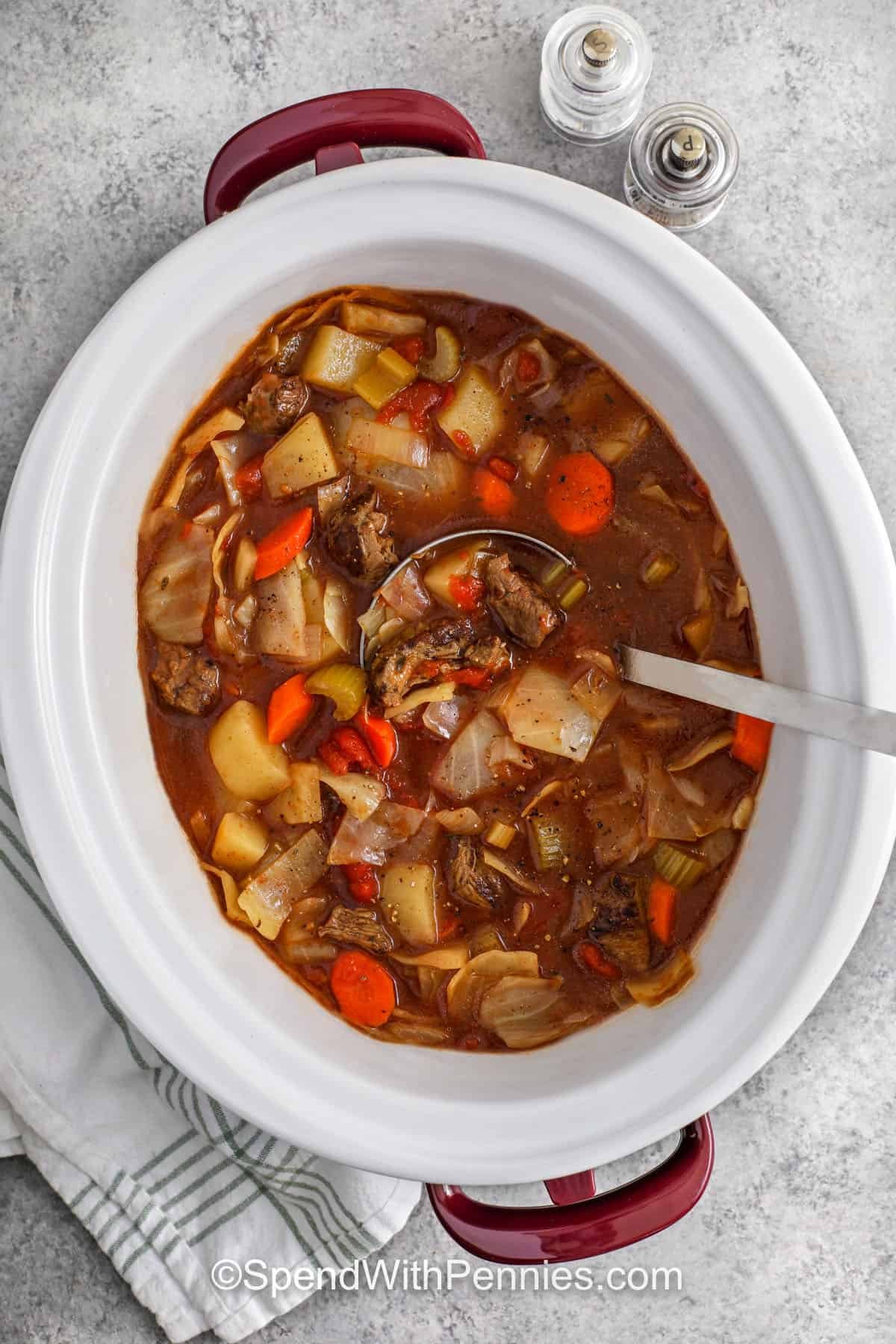 Slow Cooker Beef and Cabbage Stew in the pot with a laddle