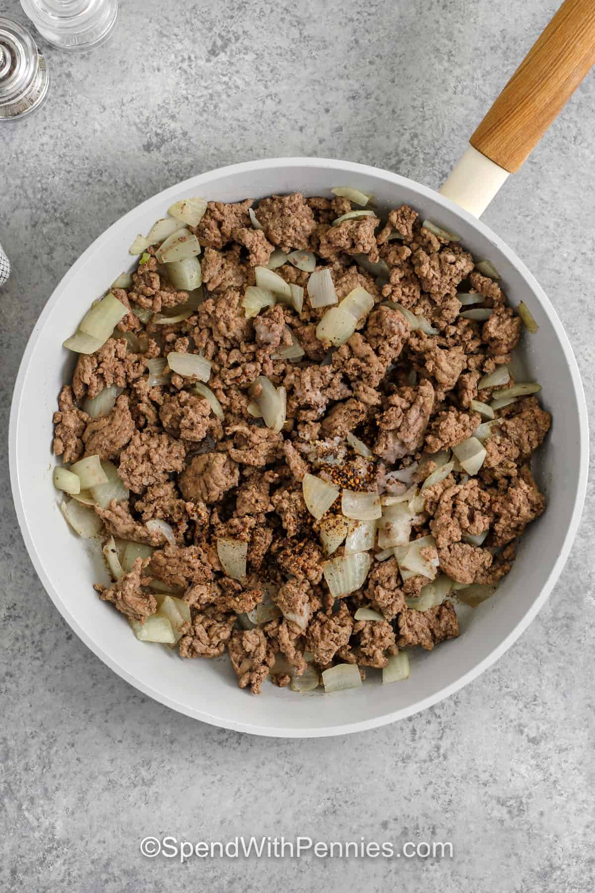 This slow cooker shepherd’s pie recipe builds classic flavor without the oven. Brown the meat and onion, then layer with frozen mixed vegetables and a savory gravy mix sauce thickened with cornstarch. Finish with prepared mashed potatoes that are thick enough to stay on top. The slow cooker makes dinner hands-off, and leftovers reheat well for easy lunches all week. #spendwithpennies cooking beef and onions to make Slow Cooker Shepherd's Pie