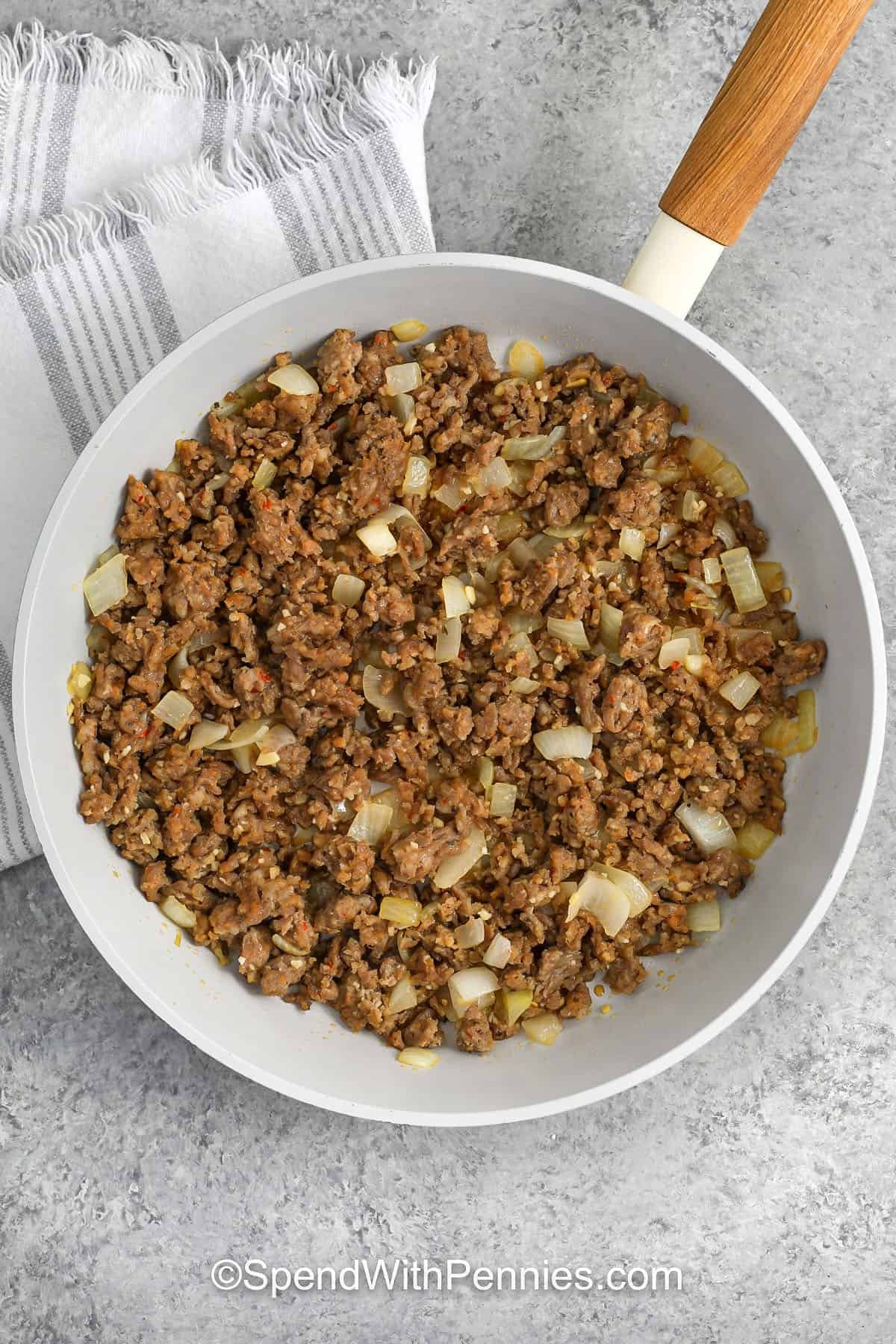 Sausage and onions browned in a skillet