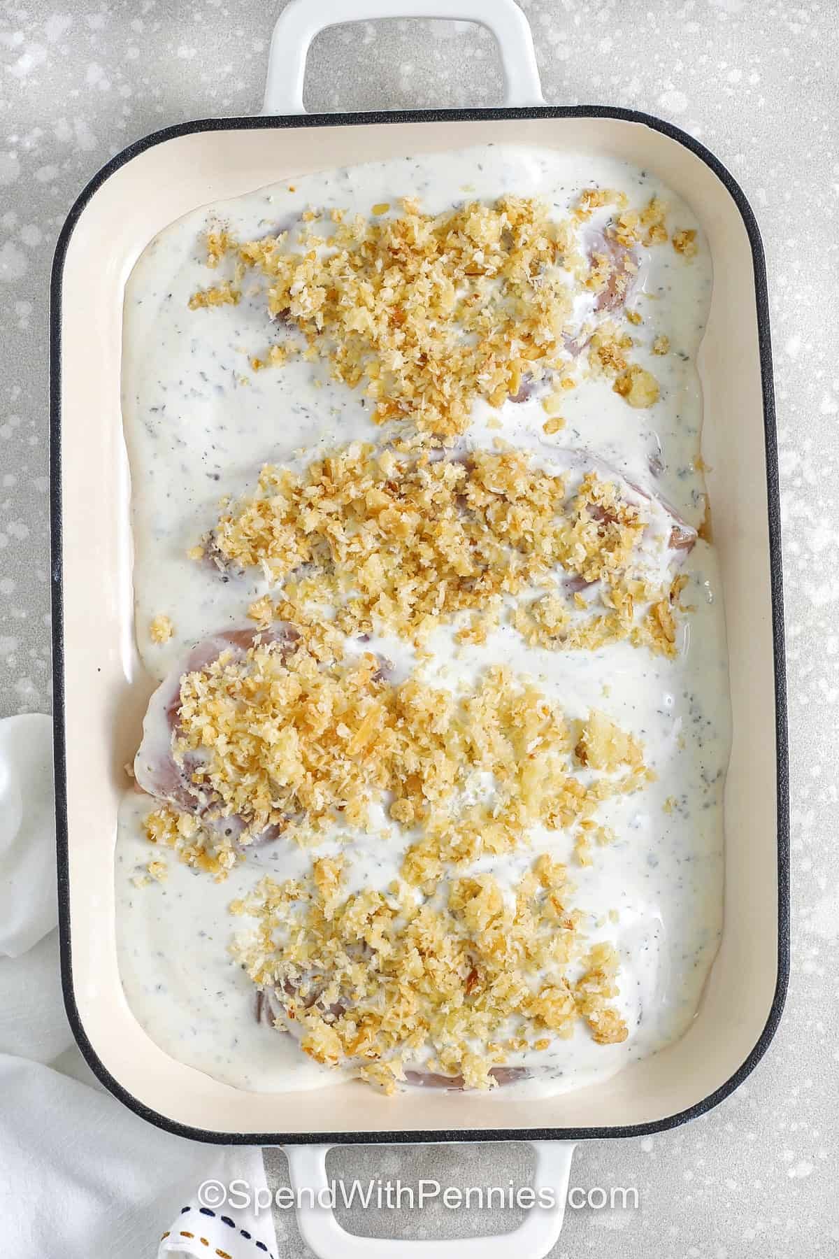 adding sour cream sauce and panko bread crumbs to dish to make Sour Cream Chicken