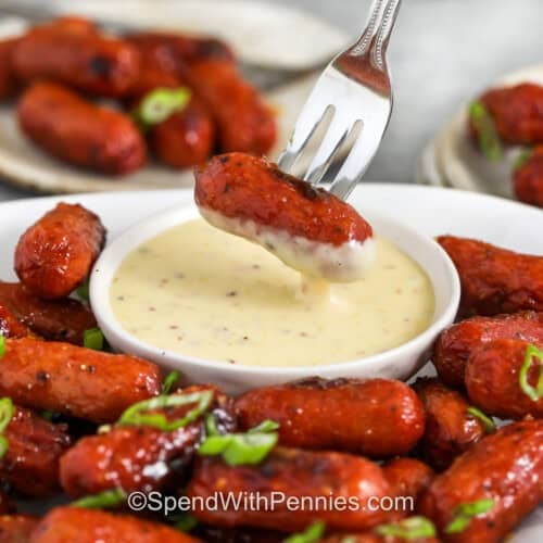dipping Sticky Honey Mustard Sausage in mustard dip