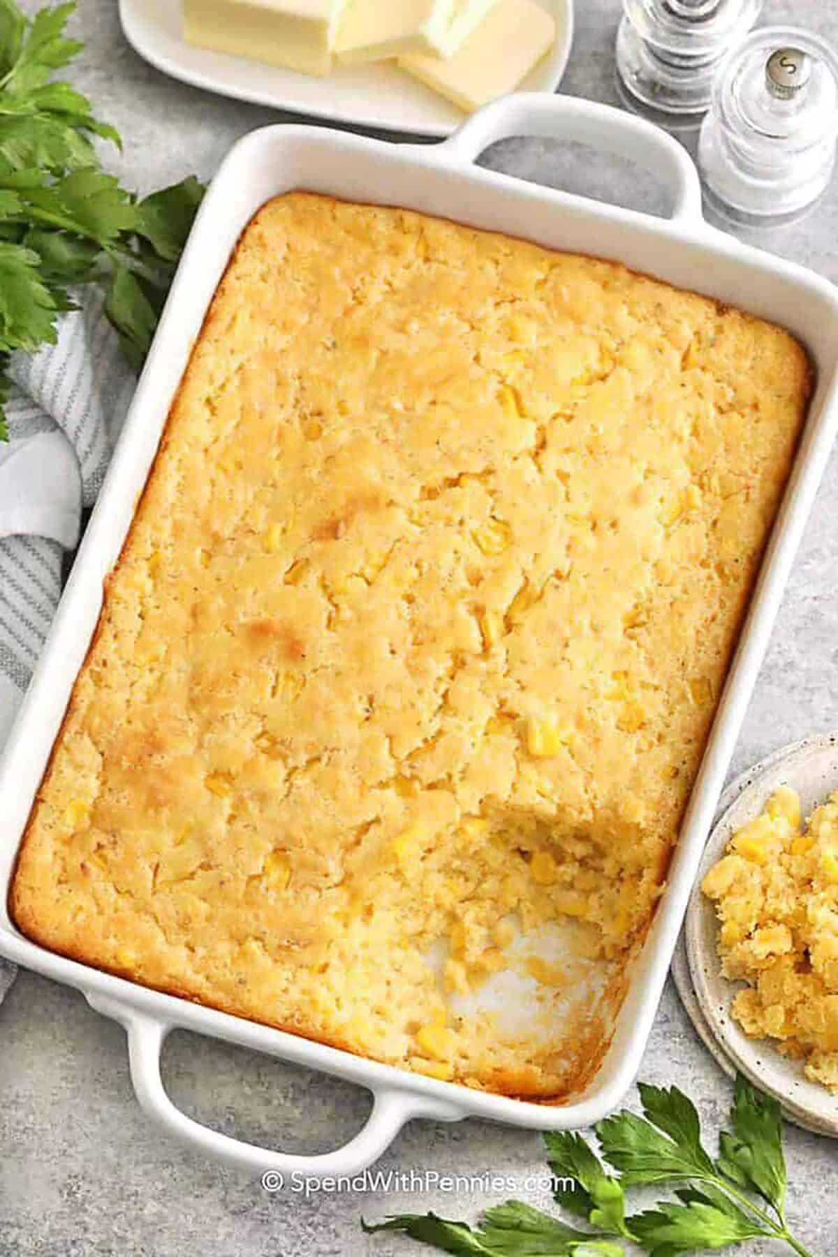 Make corn casserole with Jiffy mix when you want a reliable side that feeds a crowd. The batter stirs together quickly with eggs, melted butter, corn kernels, creamed corn, and sour cream, then bakes into a creamy, comforting casserole with a lightly crisp top. Use canned corn that is well-drained or thaw frozen corn for the best texture. Cheese or bacon bits make an easy upgrade. #spendwithpennies casserole dish of Corn Casserole with a potion taken out