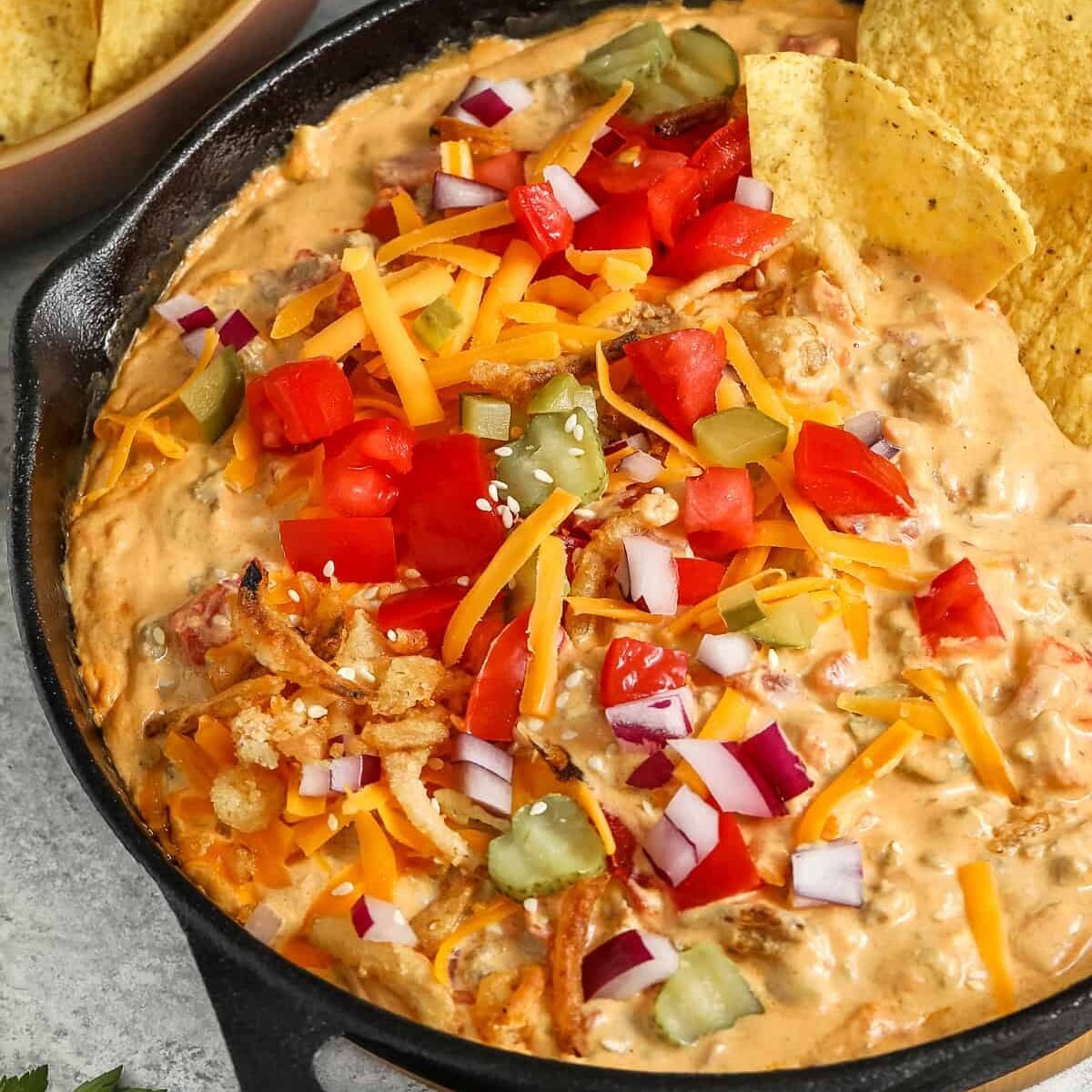 Cheeseburger Dip with toppings and tortilla chips