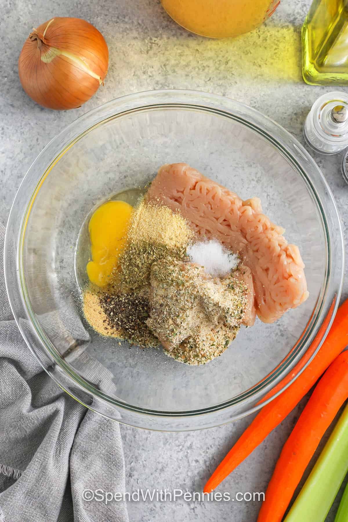 adding seasonings to chicken to make Chicken Meatball Soup