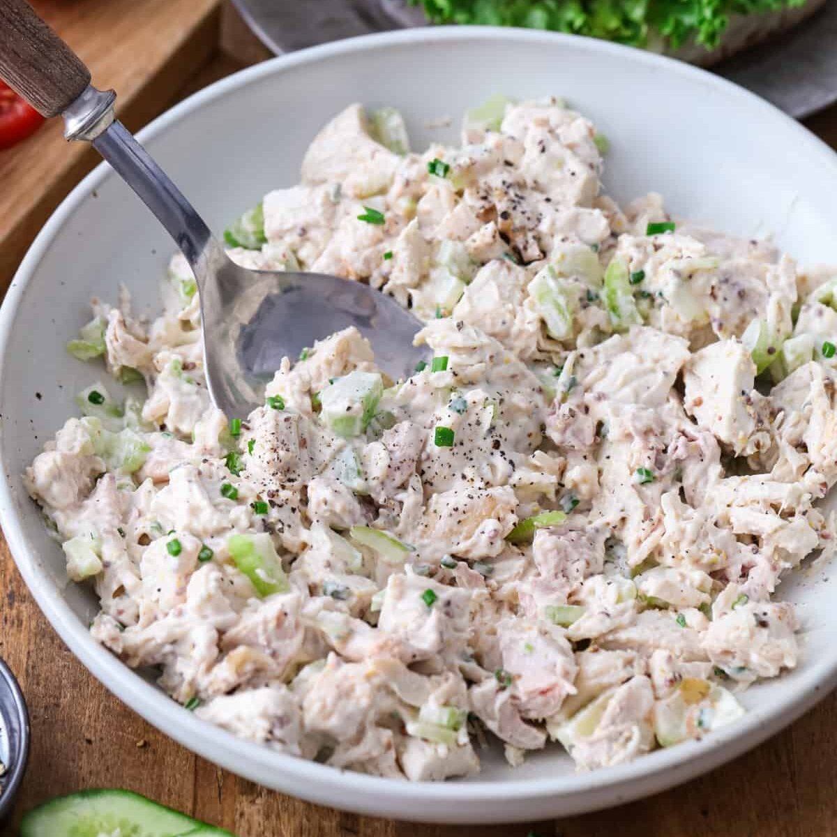 a bowl of mixed chicken salad with a spoon